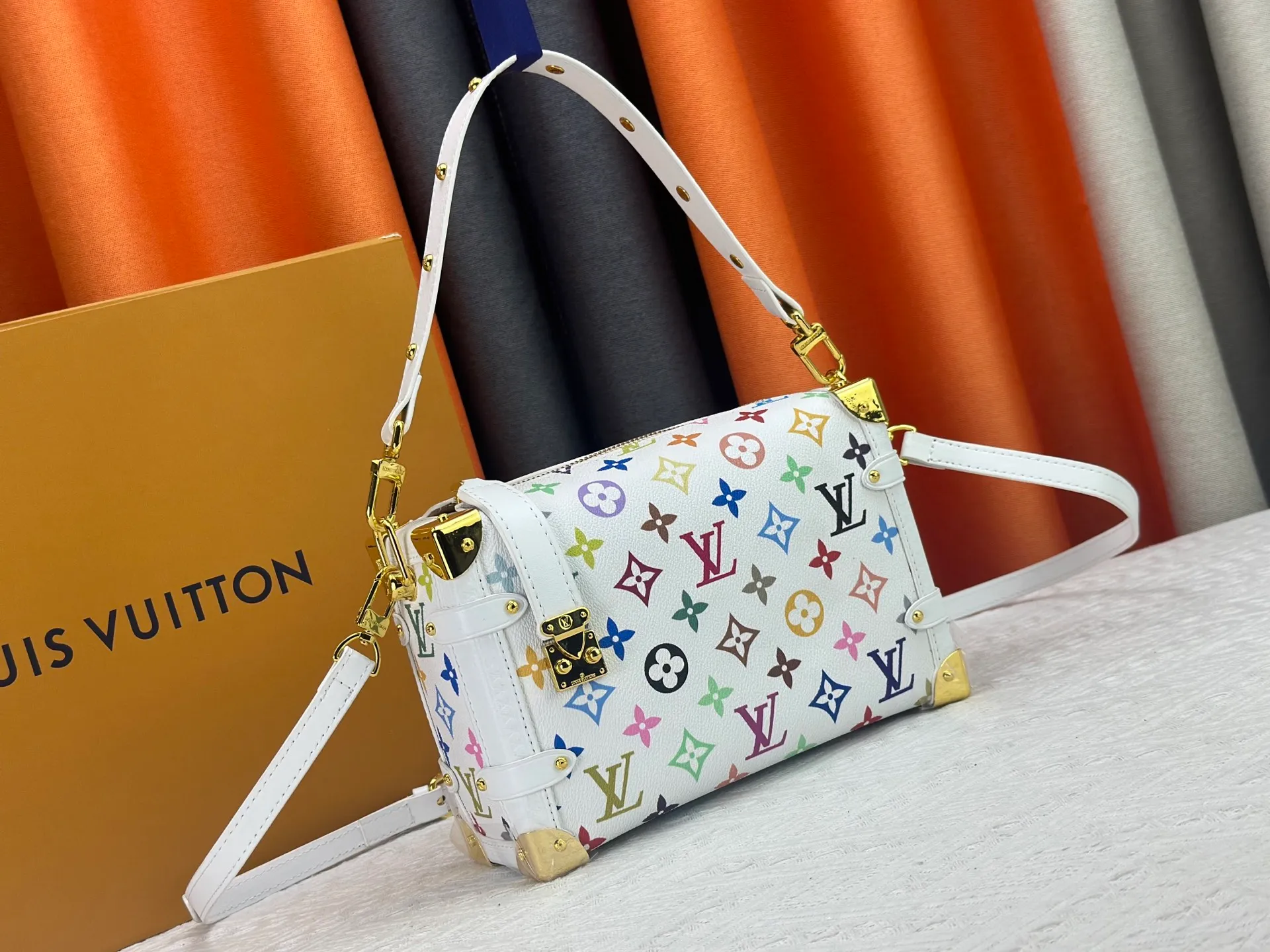 P300 M14046 M46358 Black Tricolor White Tricolor This Side Trunk medium handbag uses a humorous Monogram pattern to express the smart style of Louis Vuitton The square shape is a nod to the brand's classic luggage, and the removable studded handle and shoulder strap allow for flexible carrying. Size: 23.5x16x8.5cm