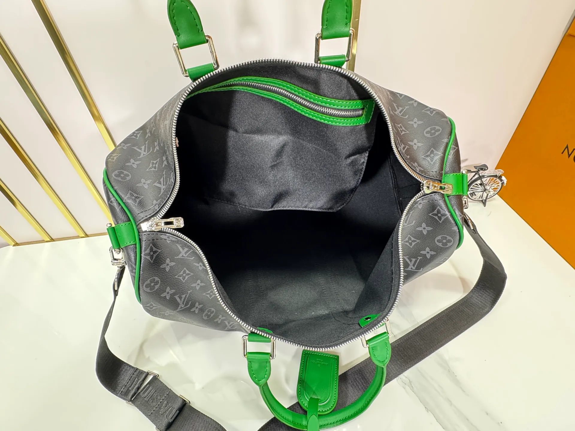 P340 M26434 M41416 Upgraded from the original version, this Keepall Bandoulière 50 travel bag is made of Monogram Eclipse canvas, with bright side straps and top handles to inject a dynamic feel. Compact construction with fabric lining and zippered pockets for on-the-go convenience. The removable and adjustable shoulder strap allows for shoulder or cross-body wear. 29 x 23 x 50 cm (height x width x length)