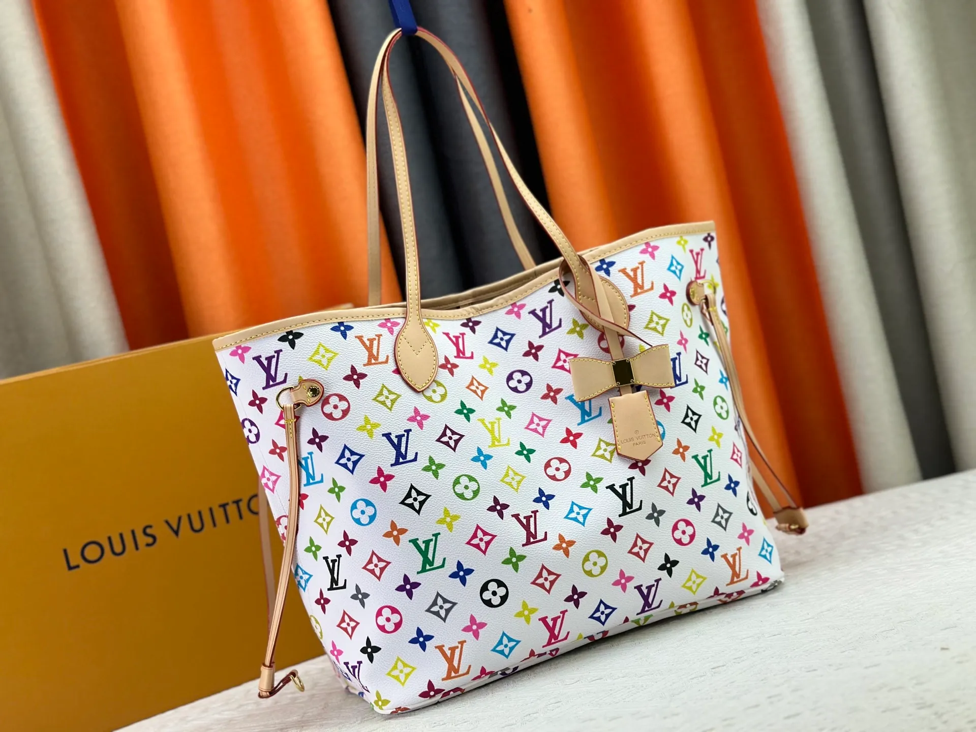 P260 Upgraded original M13675 M13271 M40995 This medium-sized Neverfull handbag is from the Louis Vuitton x Takashi Murakami reissue series. It uses Monogram canvas to create a spacious configuration, and then uses the smart Monogram floral pattern to interpret the artist's "ultra-flat" aesthetic style. Cowhide leather outlines the upper edge, handles and side straps, while the fabric lining incorporates colorful stripes. An interior zip pocket and a removable storage bag complete the functional design. Dimensions: 31.0 x 28.0 x 14.0 cm (length x height x width)