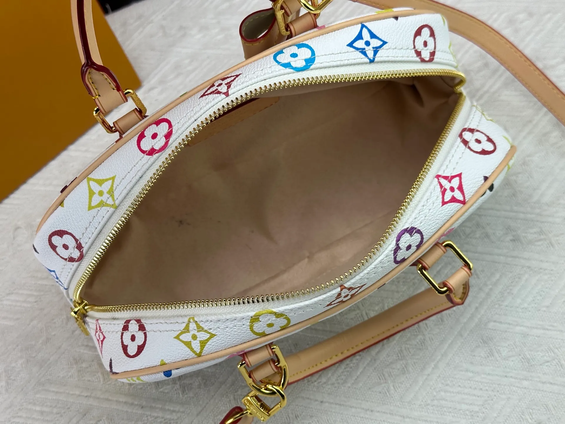 P280 Upgraded Original M13084 This Handbag East West handbag is from the Louis Vuitton x Takashi Murakami reissue series, using the artist's signature rainbow tones to trace the full-length Monogram pattern. Sleek horizontal construction lines the top handle, studded side straps, detachable and adjustable shoulder strap and LV x TM key holder, with cowhide leather details and sophisticated corners that nod to the brand's traditional luggage. Dimensions: 27.0 x 14.0 x 10.0 cm (length x height x width)
