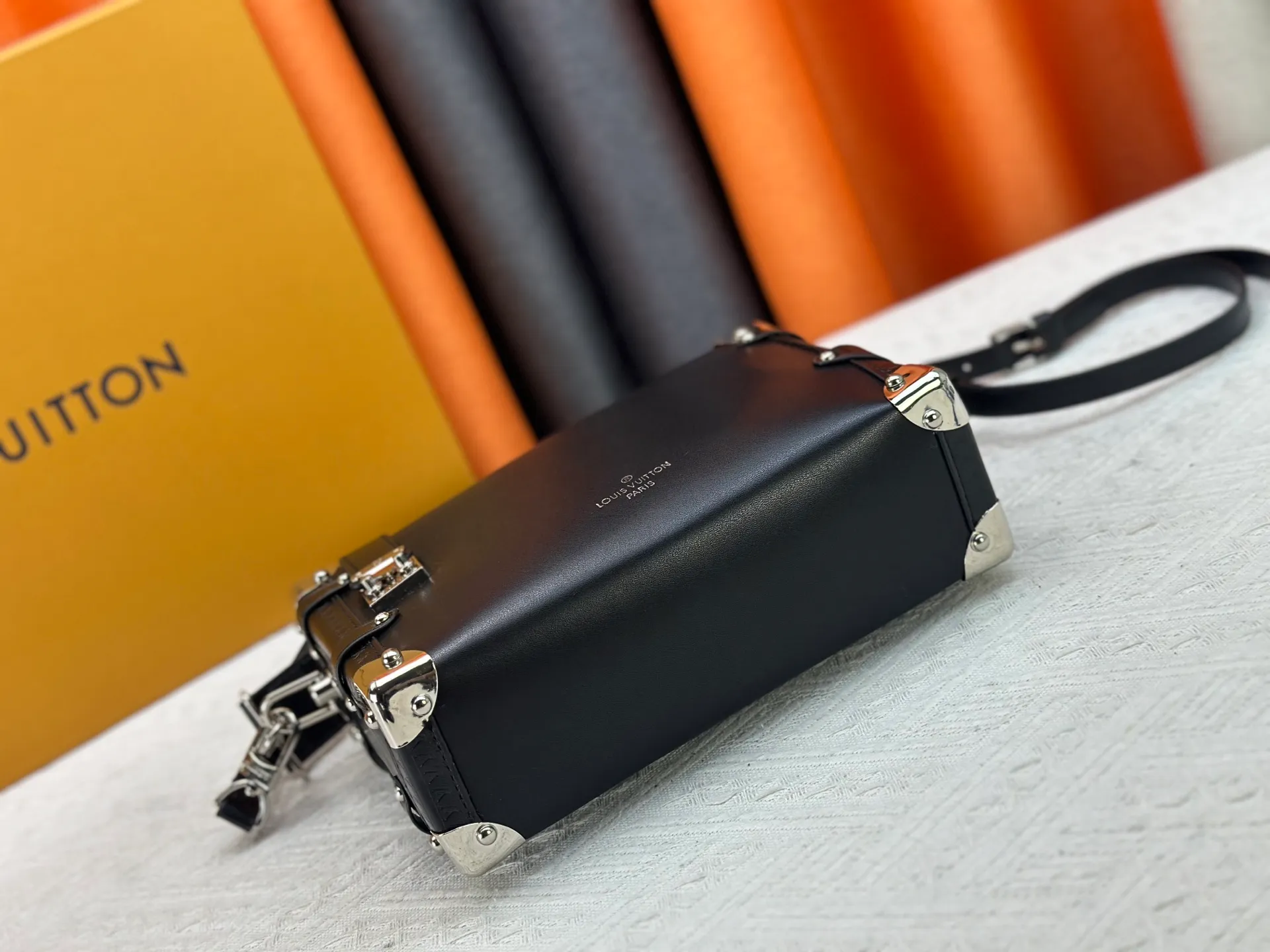 P300 M15195 M46358 This Side Trunk Vibe handbag reimagines the brand's classic Side Trunk silhouette with an avant-garde design, inspired by Louis Vuitton's traditional travel trunks. Crafted from smooth glossy Vibe textured cow leather, it features a leather-covered rivet frame and metal S-lock closure for a rock-and-roll style. Thanks to the multiple designs of the detachable chain, detachable leather handle and adjustable leather shoulder strap, it provides a variety of carrying options. Dimensions: 23.5x16x8.5cm