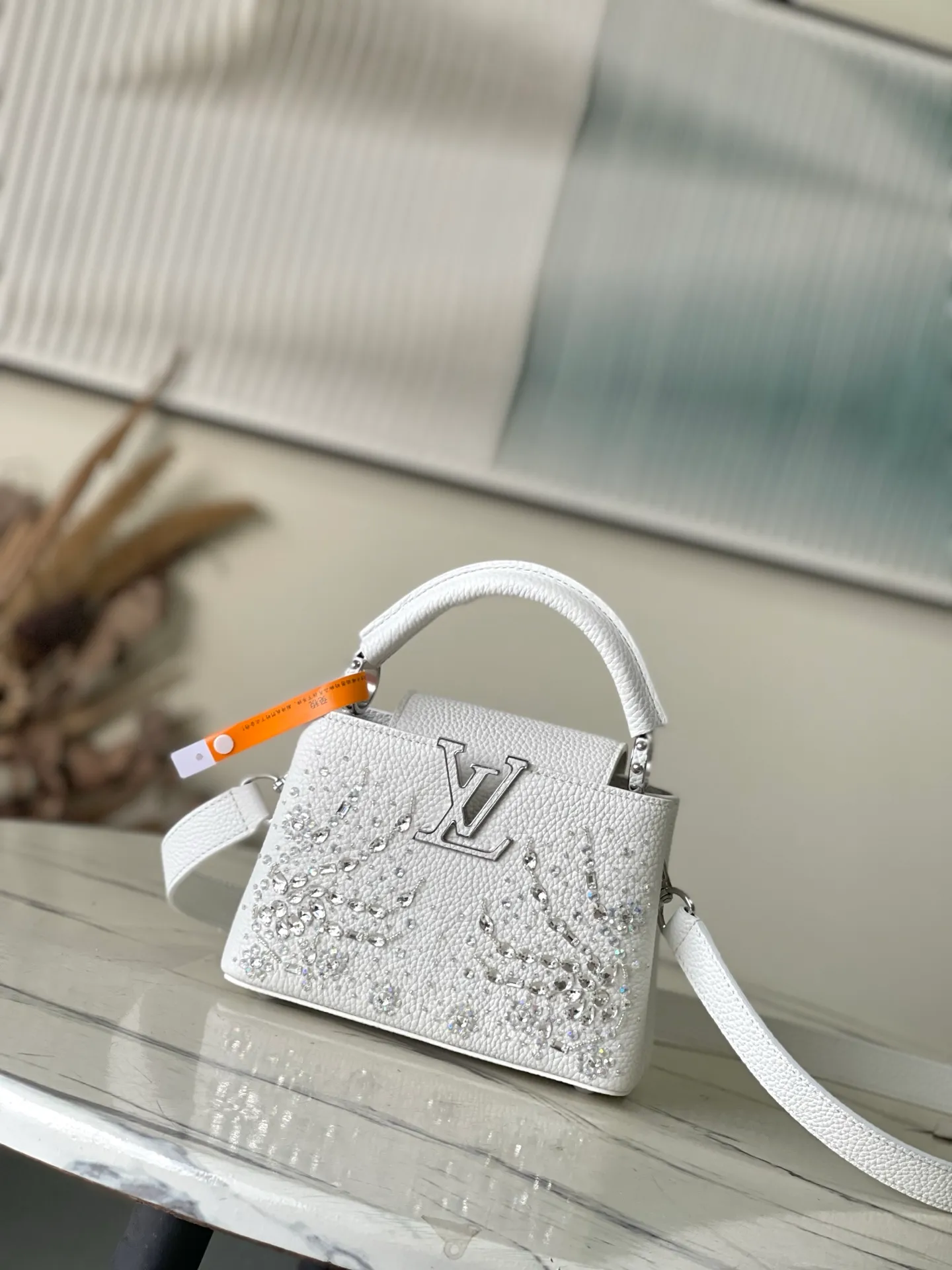 💰2700 "Special Grade Original Leather" M25934 White Mini As part of the "Extraordinary Series", this Capni mini bag has been redesigned with exquisite embroidery technology. It's made from calfskin and embellished with shimmering sequins in a romantic floral pattern and finished with gold-toned hardware. The backpack design provides a separated interior space and features the iconic LV initials as a tribute to the brand's exquisite craftsmanship. Dimensions: 21 x 13.6 x 8cm