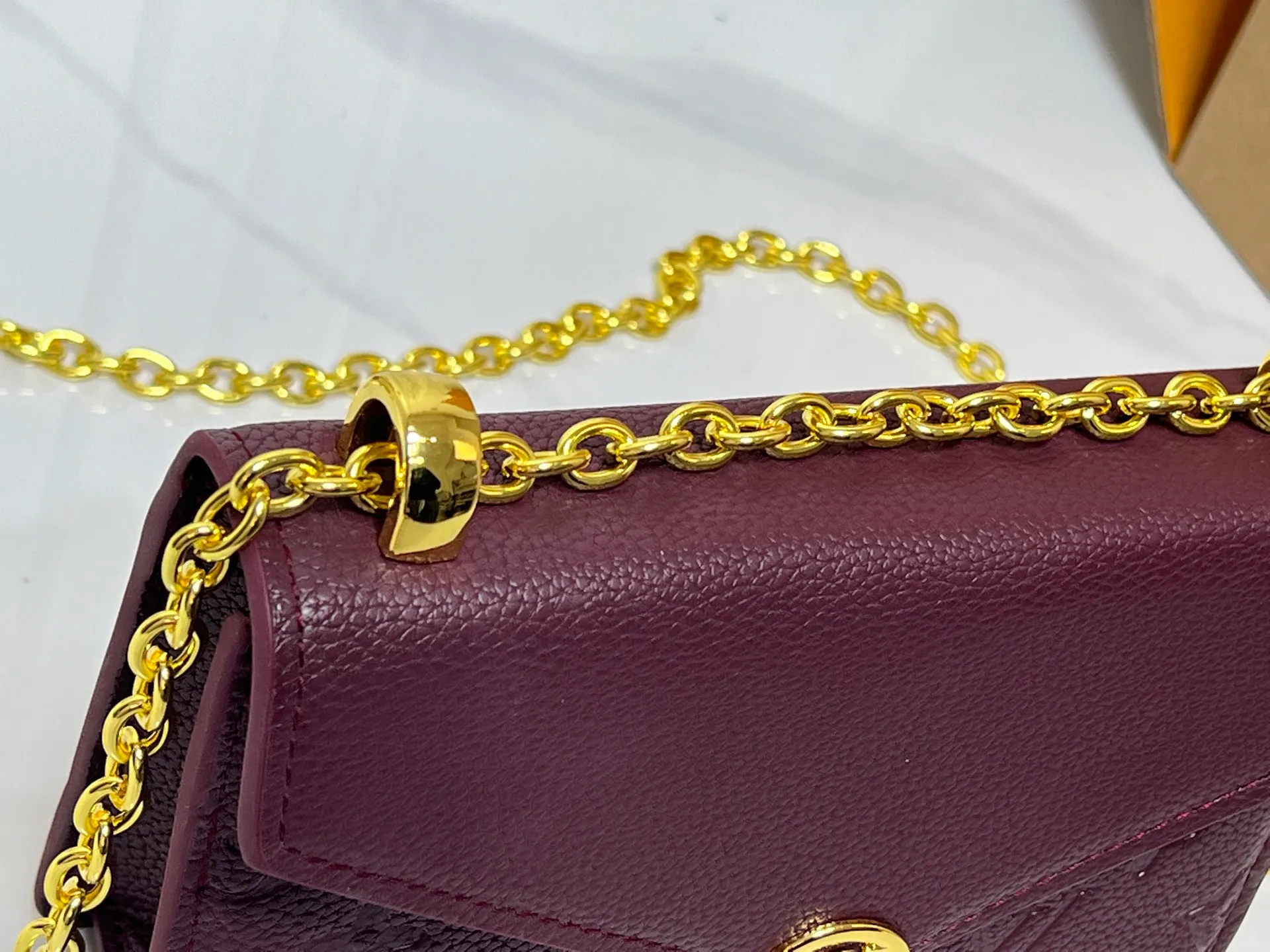 Batch 220💰M13569 black M13570 gray M25814 burgundy (chain/embossed) [Portefeuille chaîne Rosy] This Rosy chain wallet is both fashionable and practical, adding a modern spirit to the Monogram Empreinte series. It has an elegant LV circle and a V-shaped flap, two hallmarks of the house. The magnetic closure reveals a surprise Monogram flower, as well as three card slots and a flat interior pocket. The sliding chain allows you to wear it crosswise or over the shoulder.  Dimensions: 19.5 x 13.5 x 6.5 cm