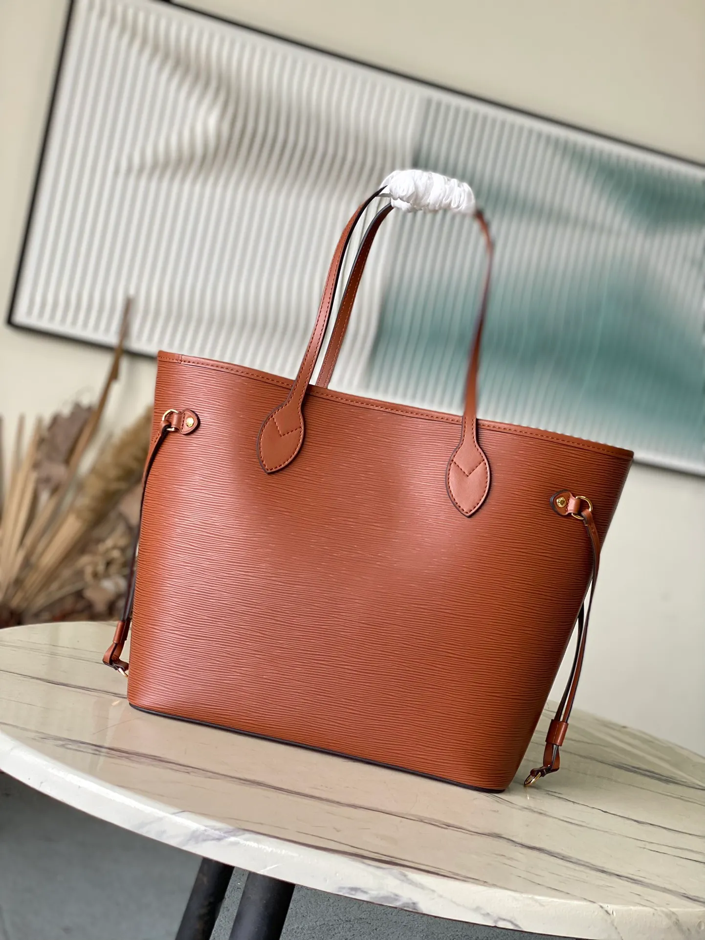 💰1320 (First-Grade Leather) Top Original M12467 Brown This classic Neverfull MM St handbag combines timeless design and traditional details, making it ideal for carrying to work and other occasions. The new version is made from signature Epi leather and has adjustable elastic straps on both sides to create a tight silhouette. The interior of the bag is spacious enough to store a 13-inch laptop, and the detachable zippered storage bag can be used as a clutch or as an extra pocket to store valuables. Dimensions: 31 x 28 x 14 cm (length x height x width)