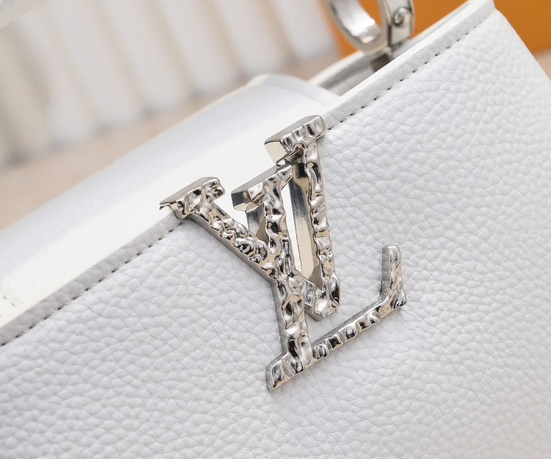 Upgraded version P420 M24671 This Capucines East West mini handbag is made of grained cow leather embellished with LV letters. Its elegant configuration includes compartments, zipper pockets and patch pockets, making it easy to store mobile phones, short wallets and other small items. The detachable and adjustable shoulder strap unlocks the shoulder-carrying experience. 22 x 12 x 8 cm (length x height x width)