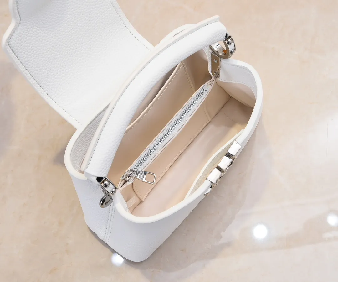 Upgraded version P420 M24671 This Capucines East West mini handbag is made of grained cow leather embellished with LV letters. Its elegant configuration includes compartments, zipper pockets and patch pockets, making it easy to store mobile phones, short wallets and other small items. The detachable and adjustable shoulder strap unlocks the shoulder-carrying experience. 22 x 12 x 8 cm (length x height x width)