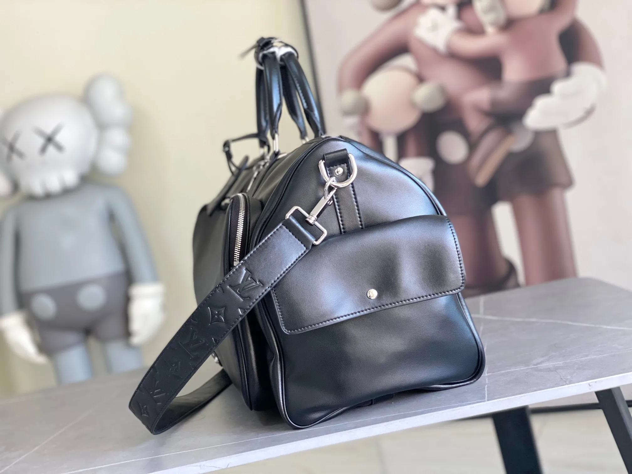 💰1760 (top layer leather) top original order M13992 This Keepall Bandoulière 50 travel bag depicts the Monogram pattern on the canvas surface and transforms into a cartoon image, making the Monogram flowers and LV letters present rich emotions of sadness or joy. The top handle and side straps are made of leather, continuing the consistent design of the Keepall series. Cartoon name tags can be customized. size：50x29x23cm