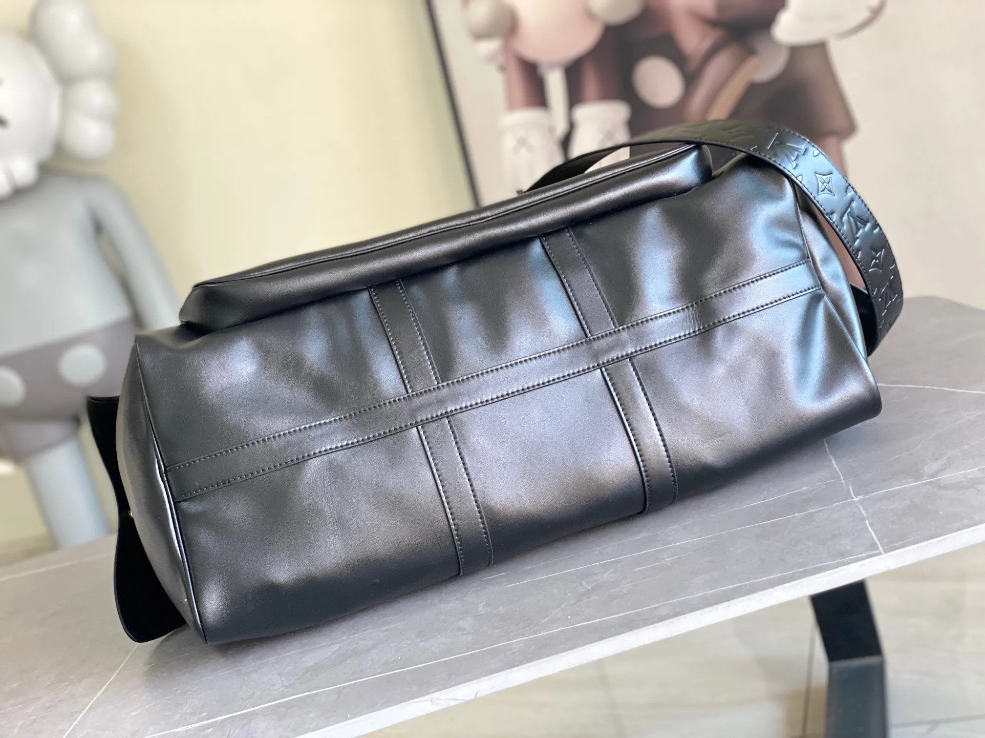 💰1760 (top layer leather) top original order M13992 This Keepall Bandoulière 50 travel bag depicts the Monogram pattern on the canvas surface and transforms into a cartoon image, making the Monogram flowers and LV letters present rich emotions of sadness or joy. The top handle and side straps are made of leather, continuing the consistent design of the Keepall series. Cartoon name tags can be customized. size：50x29x23cm