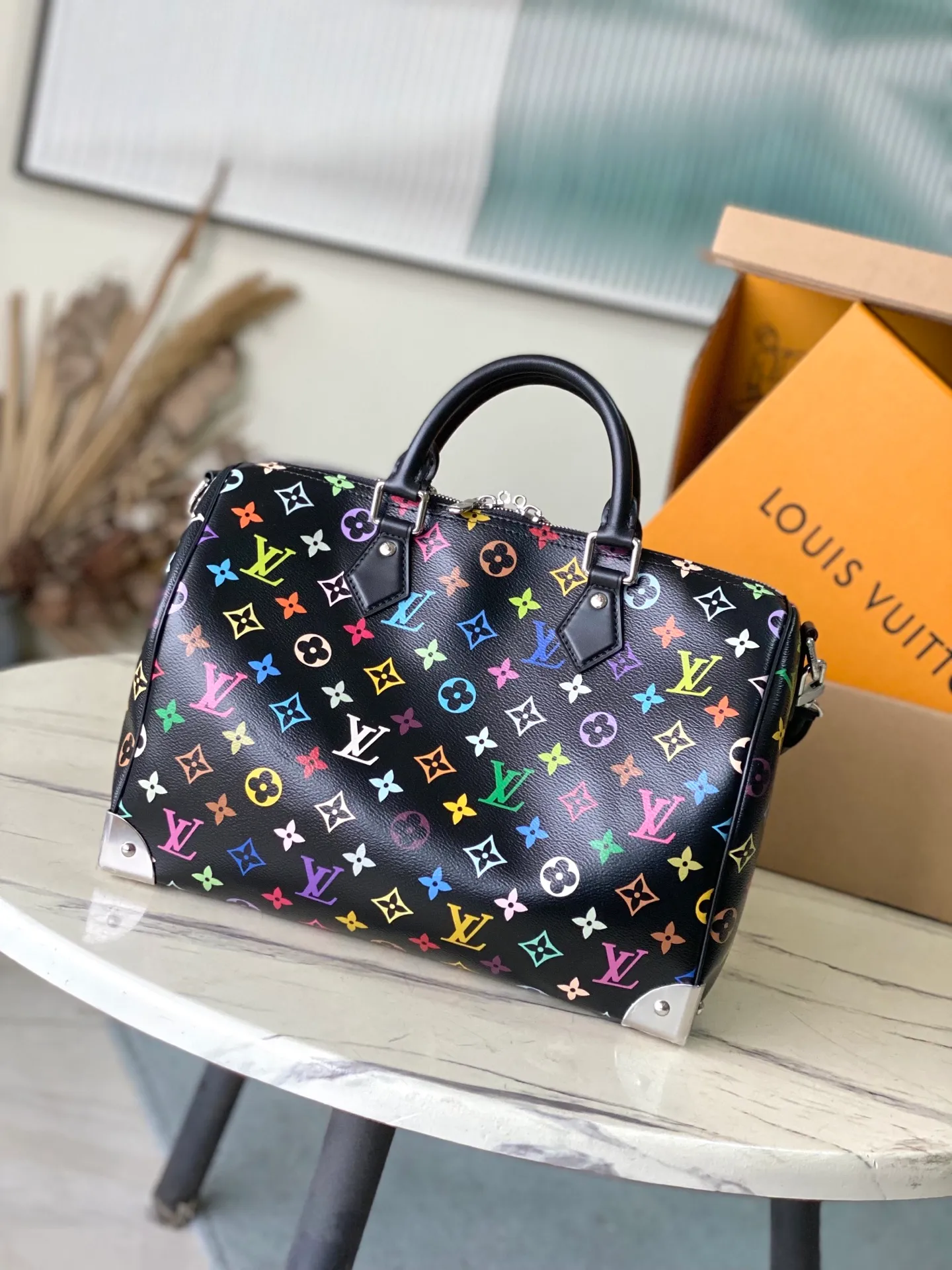 💰1180 Top Original M13257 This SpeedySoft30 handbag is made of soft coated canvas, and the full-length Monogram pattern is traced in colorful rainbow tones, highlighting the smart style of the Louis Vuitton x Murakami reissue series. The Toron handle and detachable shoulder strap are constructed of cow leather, the metal corners recall classic luggage elements, and the bow-shaped key bag and padlock add brand touches. Dimensions: 30 × 21 × 17 cm