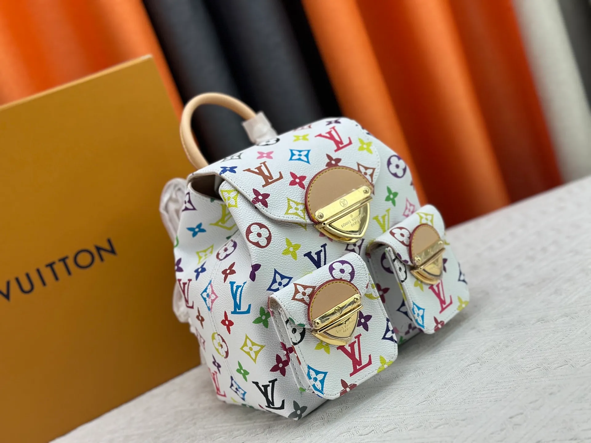 P340 Upgraded original M13081 M46836 This Venice backpack is made of coated canvas and depicts the Monogram pattern in the distinctive tones of Japanese artist Takashi Murakami, highlighting the liveliness of the Louis Vuitton x Murakami reissue series. Classic cowhide leather shapes the slim shoulder straps, and large buckles add a metallic sheen to the flap and outer pocket. Dimensions: 24.0 x 26.0 x 7.0 cm (length x height x width)