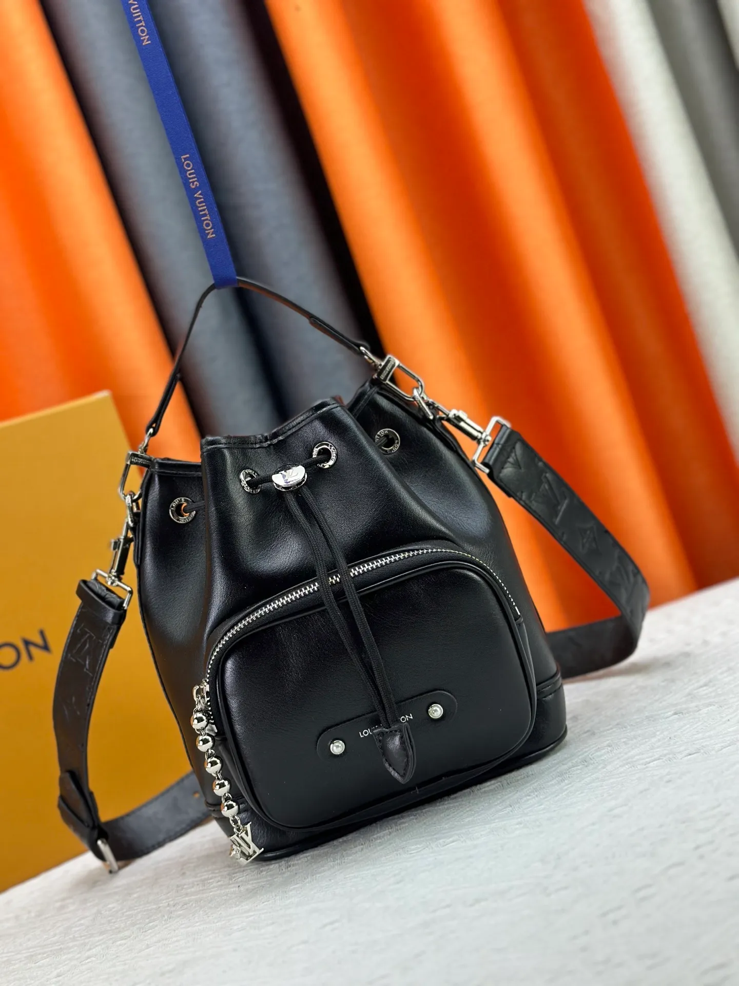P280 Upgraded original version M13985 full leather black, official small size M14017 pure presbyopia Noe Cargo is a compact bucket bag, made of shiny cow leather, showing a nylon-like technological luster, and the lining is made of deep-toned fabric. Metal parts, including the LV letters attached to a ball chain, are the only color-coordinated elements on this monochromatic bag. Roomy front pocket inside. ·Cow leather trim fabric lined with hardware Drawstring and metal closure main compartment LV pendant zip puller ·Pearl rivets Louis Vuitton Paris patch ·Zip front pocket Shoulder strap: Removable, adjustable strap Half length: 40.0 cm Dimensions: 24✘22✘16cm (H✘L✘W)