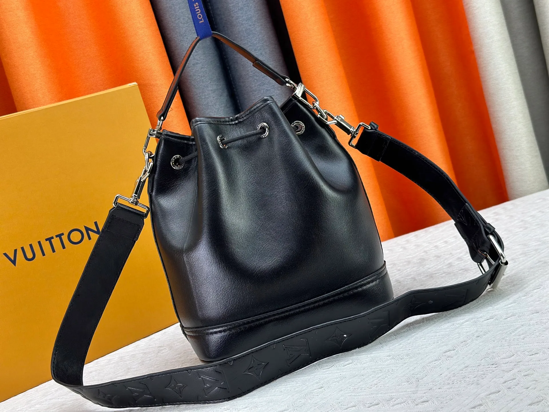 P280 Upgraded original version M13985 full leather black, official small size M14017 pure presbyopia Noe Cargo is a compact bucket bag, made of shiny cow leather, showing a nylon-like technological luster, and the lining is made of deep-toned fabric. Metal parts, including the LV letters attached to a ball chain, are the only color-coordinated elements on this monochromatic bag. Roomy front pocket inside. ·Cow leather trim fabric lined with hardware Drawstring and metal closure main compartment LV pendant zip puller ·Pearl rivets Louis Vuitton Paris patch ·Zip front pocket Shoulder strap: Removable, adjustable strap Half length: 40.0 cm Dimensions: 24✘22✘16cm (H✘L✘W)