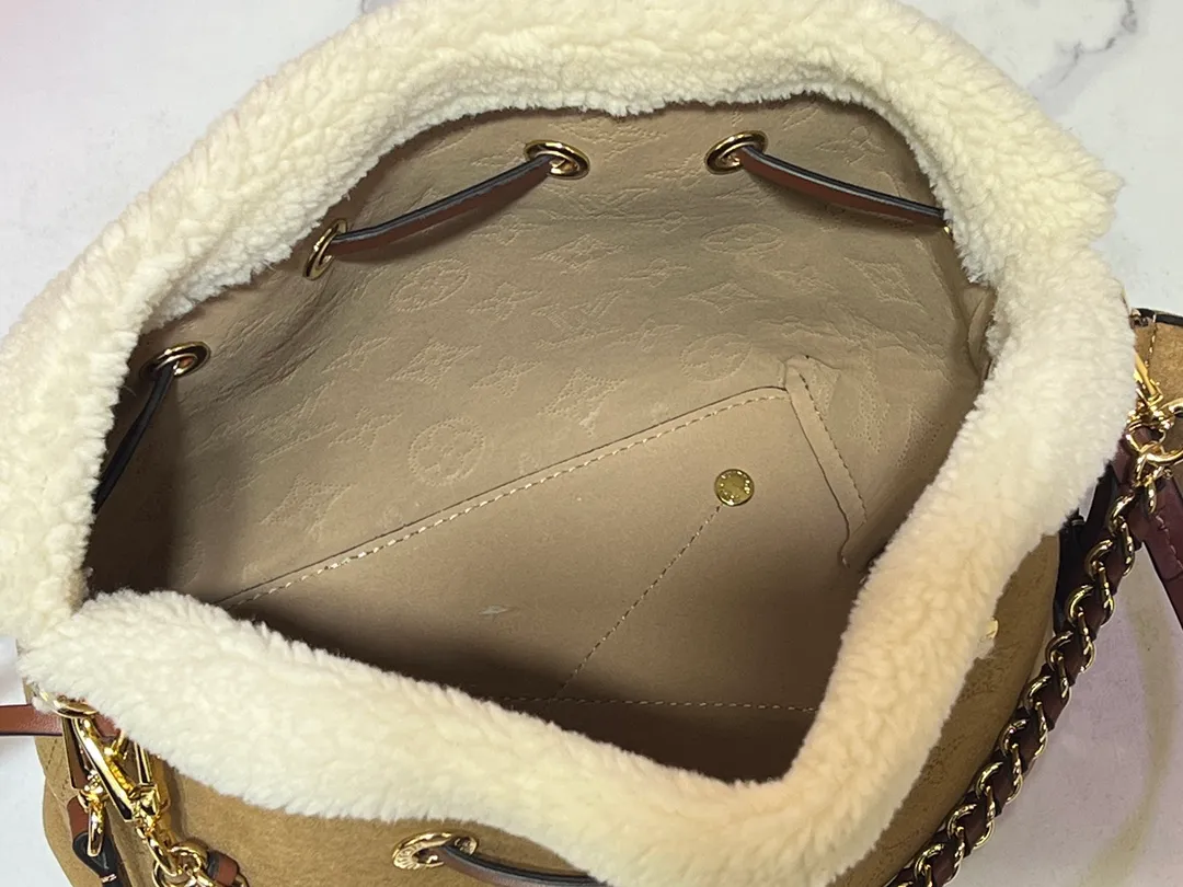 Batch 340💰Upgraded version M11839 (Cow leather digital punching process) The Bella handbag is from the LV Ski series. It is made of gorgeous engraved suede leather with shearling trim, highlighting the seasonal style with a comfortable and warm texture. The Monogram perforation pattern continues the iconic element, the chain is the finishing touch, and the round coin pocket provides secure storage. 19.0 x 22.0 x 14.0 cm (L x H x W) • Suede cow leather • Metal hardware • Round coin pocket • Metal base stud • Holds smartphone, keys, Zippy wallet and headphones • Shoulder strap: removable, adjustable • Strap half length: 50.0 cm • Strap half length adjustable to: 56.0 cm • Handle: Single handle, removable