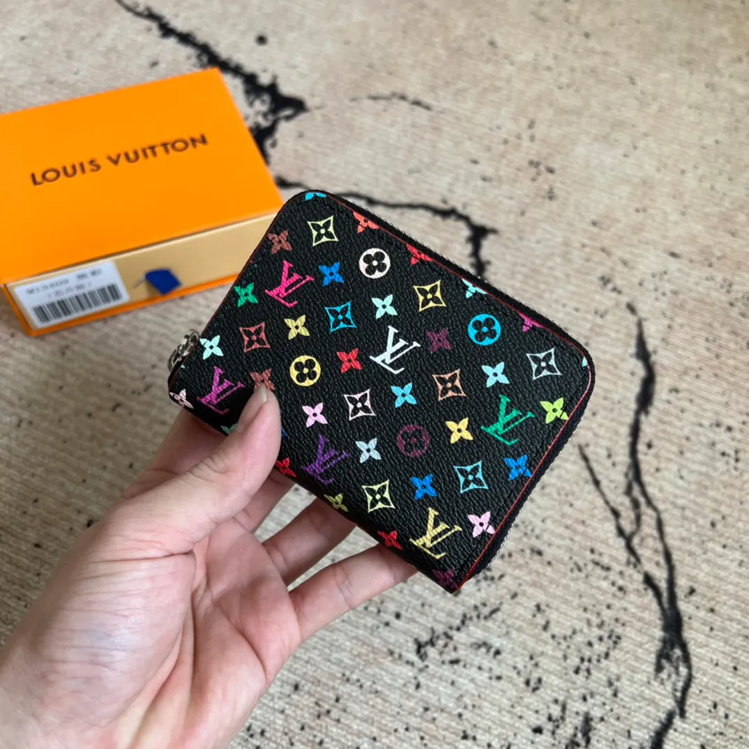 Factory Price 300 Top Original LV x TM Zippy Coin Purse M13409 Black Color (Three Colors - Murakami Takashi) As part of the Louis Vuitton x Murakami series reissue, the timeless Zippy coin purse is practical and playful, upgraded for this season. It's made from Monogram coated canvas in a cheerful rainbow of hues, in keeping with the Japanese artist's signature pop palette. The interior is secured with a silver zipper and is divided into multiple compartments for coins, banknotes and cards. Dimensions: 11 x 8.5 x 2 cm.