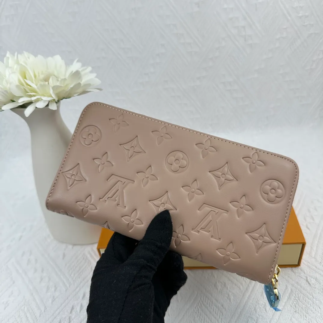 P130 M81511 Apricot Sewn with padded Monogram embossed lambskin, it complements the Coussin leather boutique series. Beautifully designed with a gold-tone zipper embossed with the LV Circle signature pull, the interior of the all-in-one wallet is packed with practical features, including three large compartments, a coin compartment and 12 business card slots. Dimensions: 19.5 x 10.5 x 2.5 cm