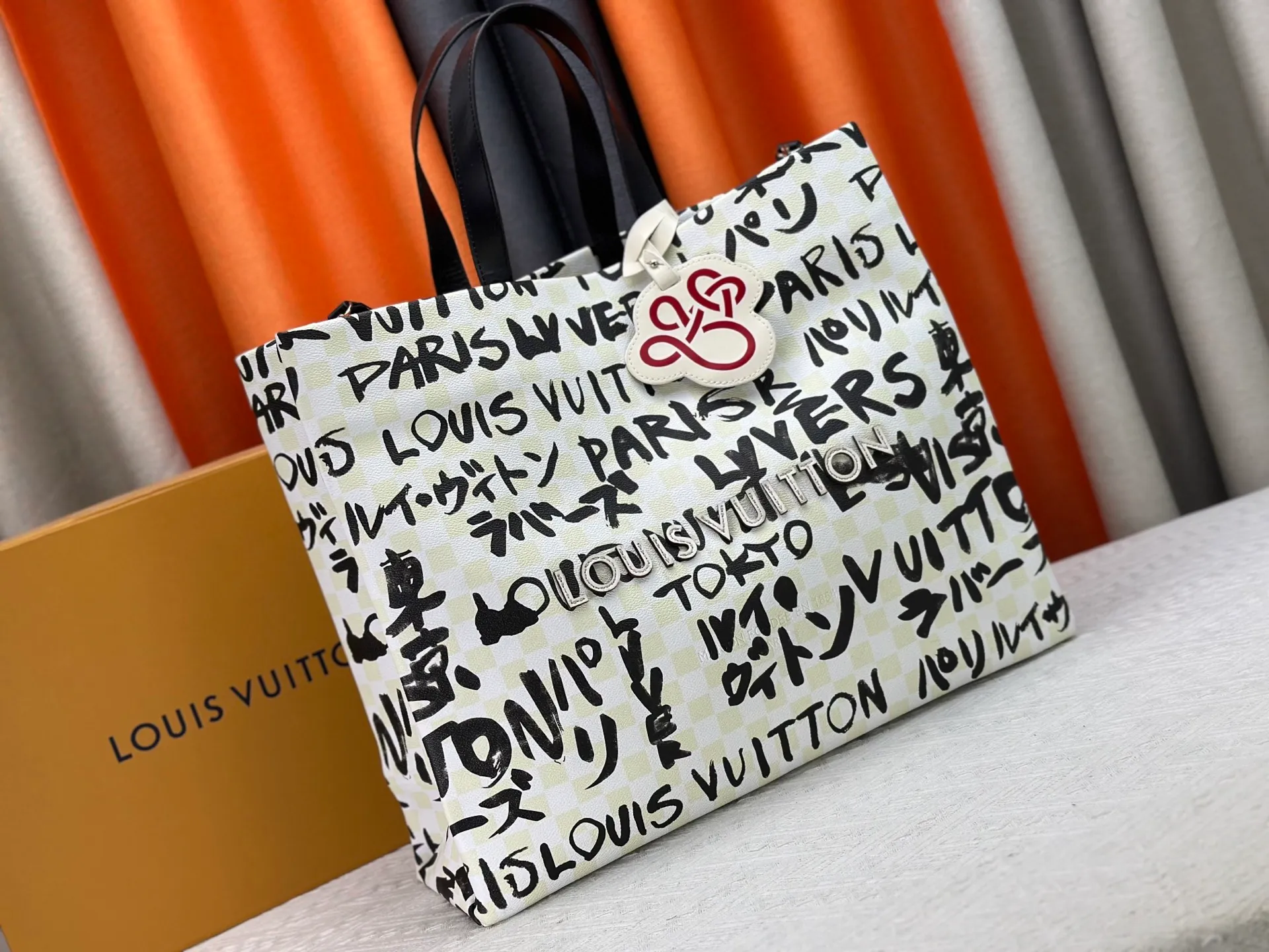 P300 M24457 M40797 This Shopper Tote medium handbag features Damier checkerboard pattern superimposed with eye-catching hand-painted elements, witnessing the joint creativity of Pharrell Williams and Japanese designer Nigo. The names Louis Vuitton, Paris and Tokyo, as well as the word Lvvers, are bilingual in French and Japanese, and the graphic cotton lining showcases Nigo's signature style. Size: 41x34x16cm
