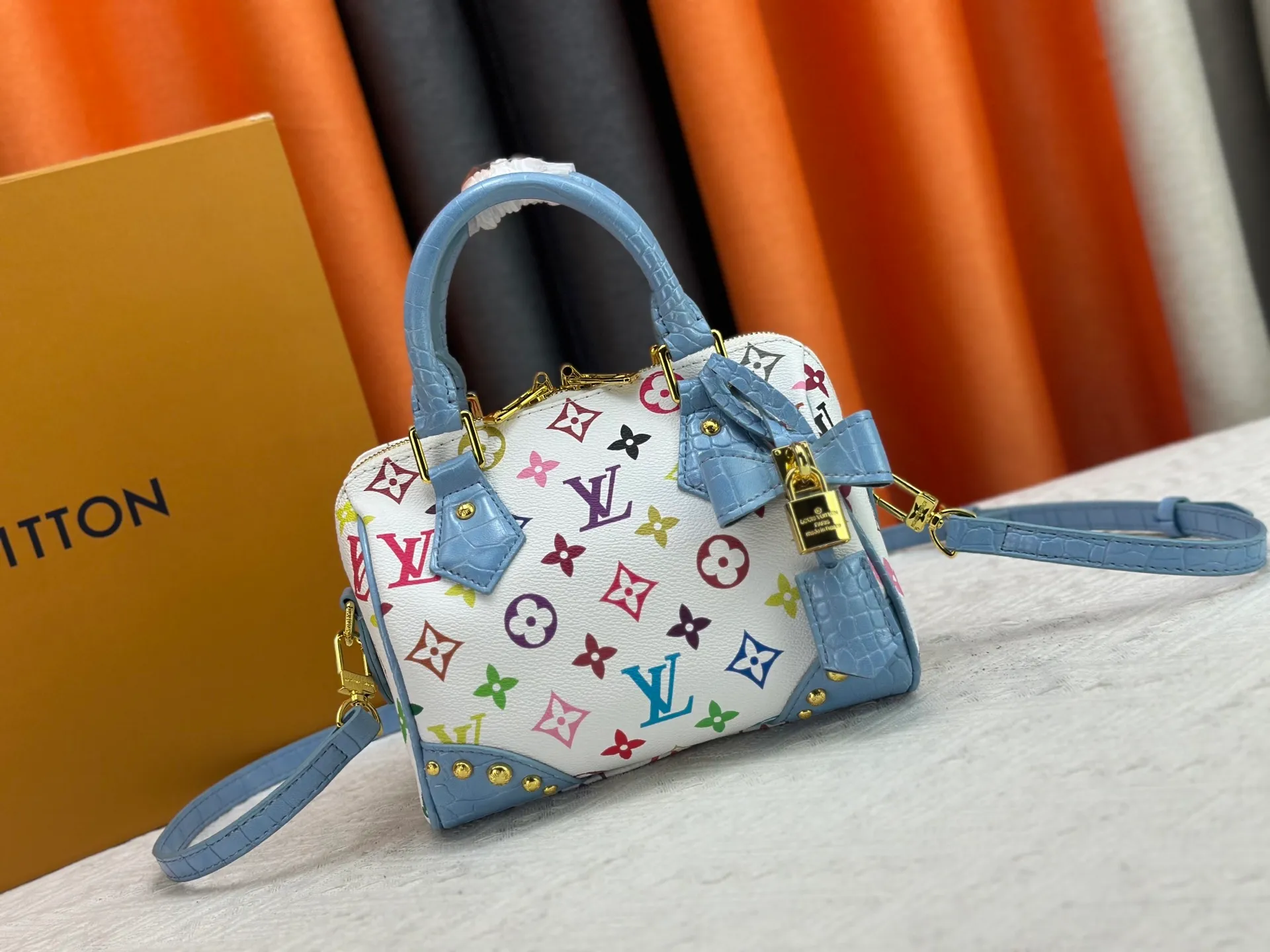 P260 Upgraded original crocodile pattern M13365 M58953 M46234 M46222 Speedy Bandoulière 20 handbag is made of soft coated canvas, and the full-length Monogram pattern is traced in colorful rainbow tones, highlighting the smart style of the Louis Vuitton x Murakami reissue series. The Toron handle and detachable shoulder strap are constructed of cow leather, the metal corners recall classic luggage elements, and the bow-shaped key bag and padlock add brand touches. Dimensions: 20.5 x 13.5 x 12.0 cm (length x height x width)