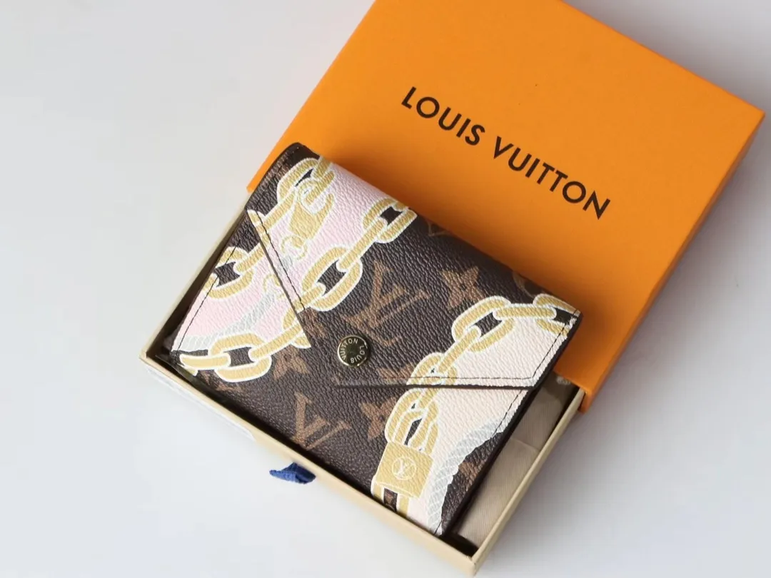 P130, M40468 Chic "Portefeuille Victorine" in printed canvas. Damier Azur canvas is combined with marine-inspired patterns in feminine rope and chain tones. Small flap wallet with three pockets and six card slots, fastened with gold-tone snap buttons and engraved Louis Vuitton signature. Size: 12*9.5*1.5cm