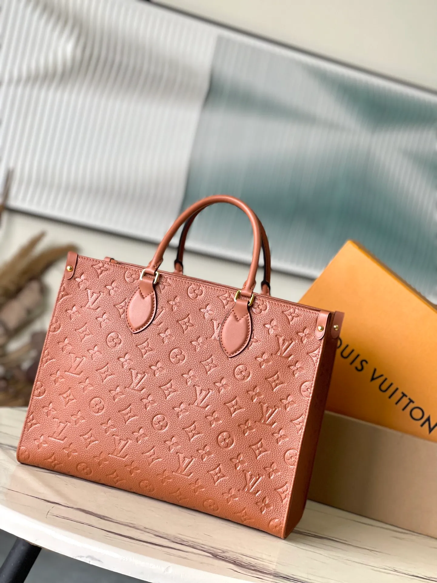 💰1140 (top-grain leather) Top-quality original order M12775 This medium-sized OnTheGo handbag is inspired by retro hard cases. The brand's iconic Monogram Empreinte leather is dyed with rich colors and matched with exquisite metal parts. The ample structure can accommodate a 13-inch laptop, and there are multiple inner pockets for convenient storage of items. Long and short handles enable multiple carrying methods. Dimensions: 35 × 27 × 14 cm