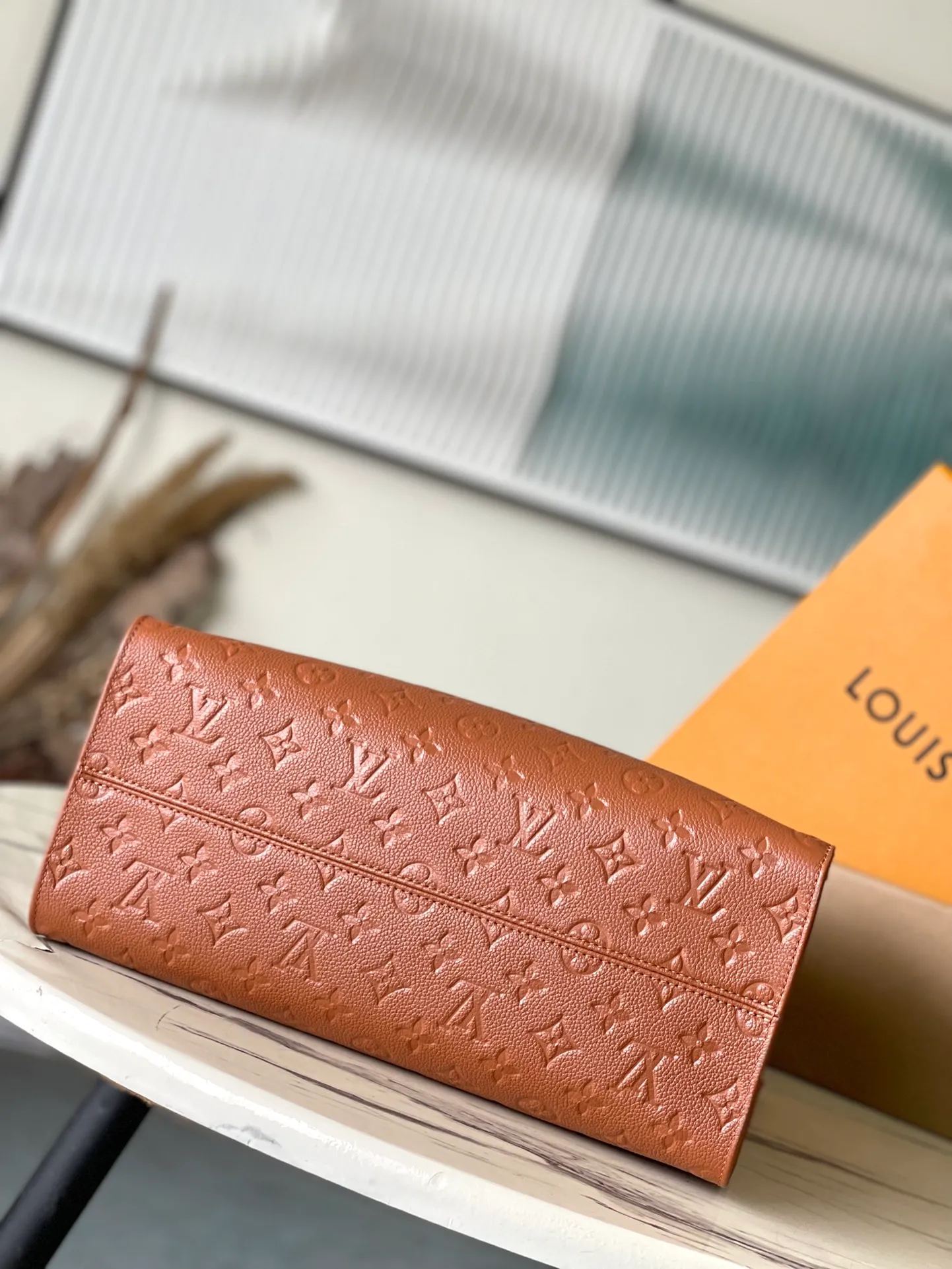 💰1140 (top-grain leather) Top-quality original order M12775 This medium-sized OnTheGo handbag is inspired by retro hard cases. The brand's iconic Monogram Empreinte leather is dyed with rich colors and matched with exquisite metal parts. The ample structure can accommodate a 13-inch laptop, and there are multiple inner pockets for convenient storage of items. Long and short handles enable multiple carrying methods. Dimensions: 35 × 27 × 14 cm