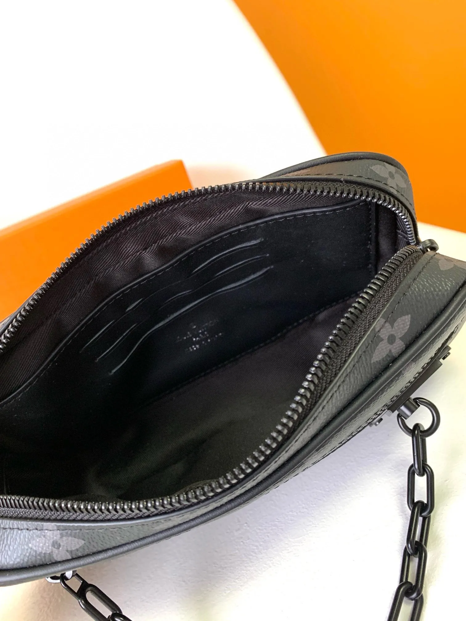 💰680 Top original single M68321 Black flower M55703 Embossed top original single The 2019 spring and summer show unveiled the Pochette Volga clutch designed by Virgil Abloh. Monogram Eclipse canvas is accentuated by a slender chain attached to the front zip pocket, with a detachable wrist strap that can be worn as a clutch or wallet. 23.0 x 11.5 x 4.0 cm (L x H x W) • Monogram Eclipse coated canvas • Textile lining • Cow leather trim • Metal hardware • Zip front pocket • Internal zip compartment • Handle: Single handle, removable