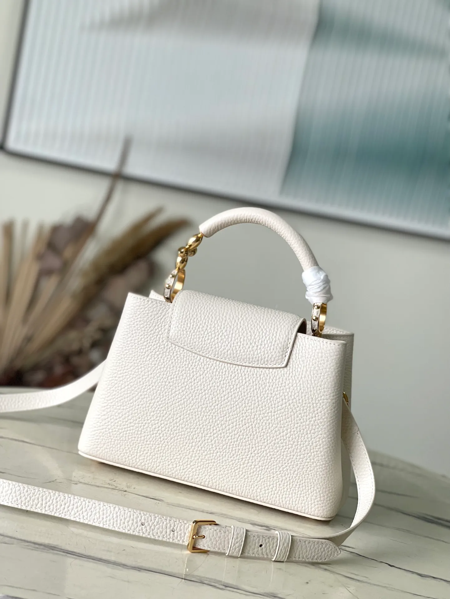 💰2360 (special grade original leather) M23944 small white size. This Capucines BB handbag is made of Taurillon cow leather embellished with shiny metal parts, and the LV letters are written with 3D strokes. Metal Monogram flowers bloom quietly on the rolled leather handle, subtly proving the brand's exquisite craftsmanship. The detachable and adjustable leather shoulder strap allows for comfortable shoulder carrying. Dimensions: 26.5 × 17.5 × 9 cm
