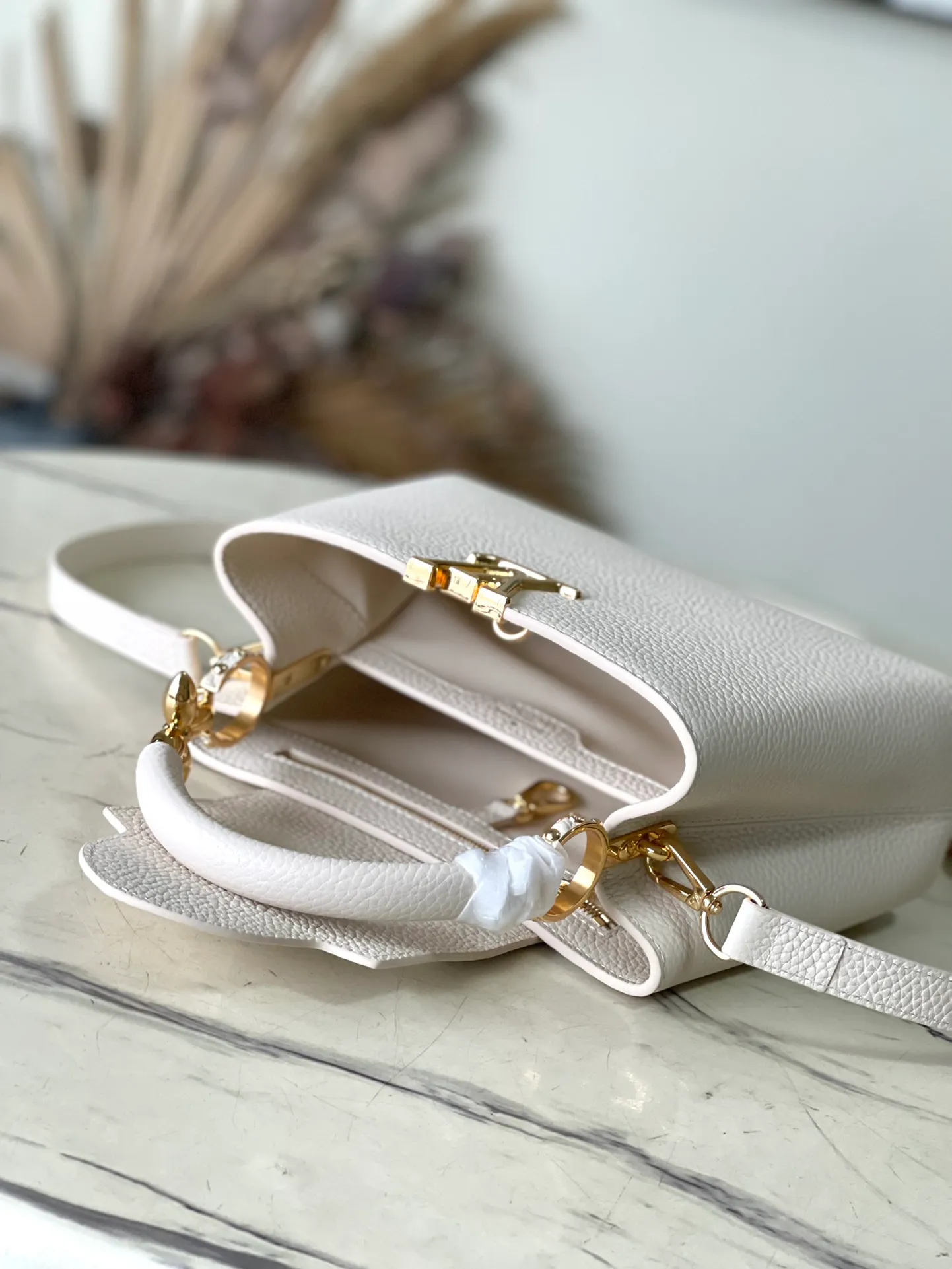 💰2360 (special grade original leather) M23944 small white size. This Capucines BB handbag is made of Taurillon cow leather embellished with shiny metal parts, and the LV letters are written with 3D strokes. Metal Monogram flowers bloom quietly on the rolled leather handle, subtly proving the brand's exquisite craftsmanship. The detachable and adjustable leather shoulder strap allows for comfortable shoulder carrying. Dimensions: 26.5 × 17.5 × 9 cm
