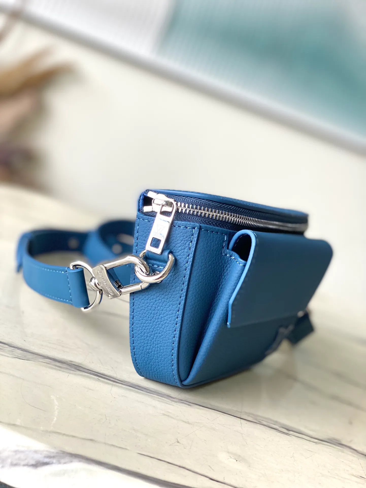 💰940 (top layer leather) top original order M83563 blue. This Pilot mini handbag is made of grained cow leather with a round shape, providing a trendy choice for daily travel. A zippered main compartment ensures secure storage, and a front pocket provides easy access to small items like your phone or keys. Detachable shoulder strap allows for comfortable shoulder or cross-body wear. Dimensions: 20 × 12 × 5,5 cm