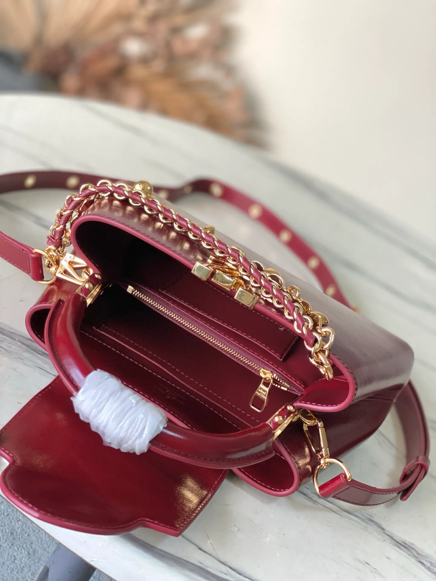 💰2360 "Special Grade Original Leather" M25473 Small Burgundy Oil Waxed Leather This Capucines East-WestBB handbag gives the leather a pleated texture and expresses the new season trend. The cow leather trim outlines smooth lines. The LV letters and detachable chain shine with metallic luster. The spacious interior meets different storage needs. Various carrying methods show functional ingenuity. Size: 26.5*14*8CM