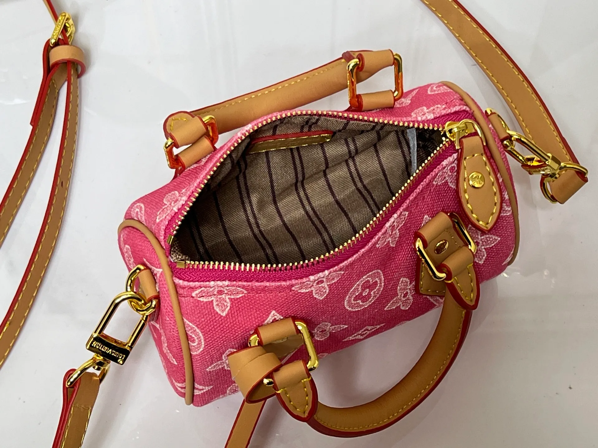 Batch 240💰M28322 Red M28323 M27610 M81085 [Exclusive background shot] This Nano Speedy handbag condenses the configuration of Louis Vuitton's classic Speedy handbag. It is made of Monogram canvas with distressed cow leather details and dazzling metal parts, making it easy to carry with you for daily needs. The handles and removable and adjustable shoulder strap allow for a variety of styling possibilities. 16.0 x 10.0 x 7.5 cm (L x H x W) • Monogram coated canvas • Cow leather trim • Metal hardware • Zipper closure • Space to store daily necessities such as a 6.1-inch smartphone, card holder and lipstick • Shoulder strap: removable, adjustable • Half-length strap: 45.5 cm • Half-length strap adjustable to: 54.0 cm • Handle: Double handle