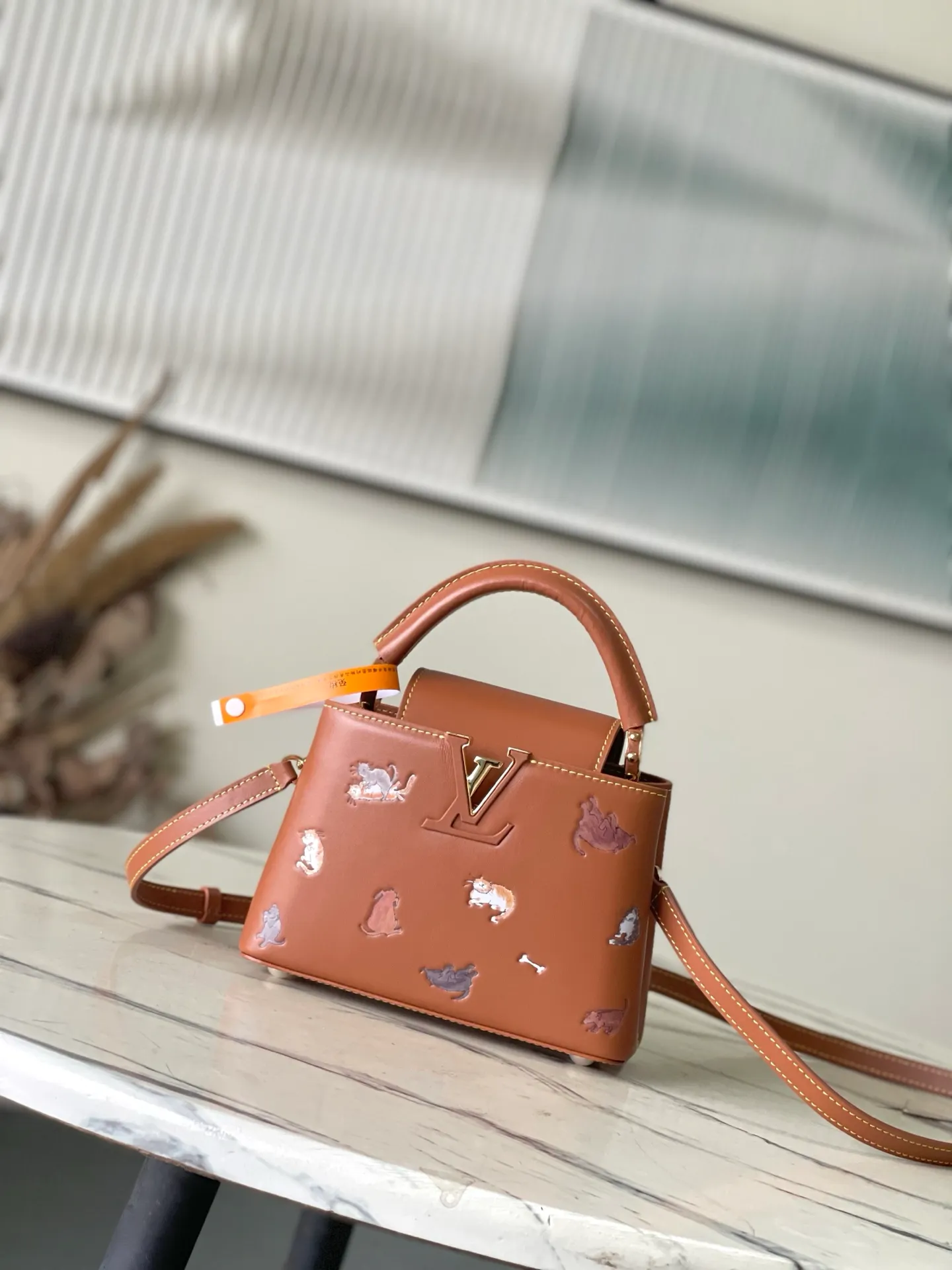 💰2200 "Special Original Leather" M25874 Mini LV Travels With series renders the Capucines mini handbag in classic colors, adding smart details with cat illustrations hand-drawn by fashion icon and artist Grace Coddington. This replica is derived from the first collaboration in 2019 and features a cowhide body with LV letters. The flip cover can be folded in or out, and the detachable long shoulder strap allows for a variety of carrying methods. 21 x 13.6 x 8cm