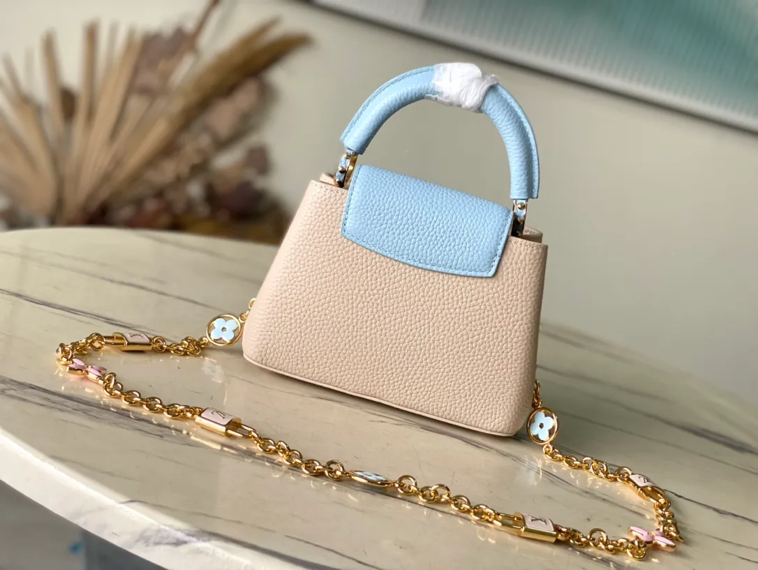 💰2200 (Special grade original leather) M23952 mini This Capucines mini handbag comes from the Lovelock Chain series. The Taurillon leather bag has a dotted rope that looks like a jewelry chain, with a padlock and pastel enamel Monogram flowers, echoing the dual tones of the leather. The detachable chain and top handle provide more carrying options, and the inner pocket is equipped with a small mirror for easy touch-ups at any time. Dimensions: 21 × 14 × 8 cm