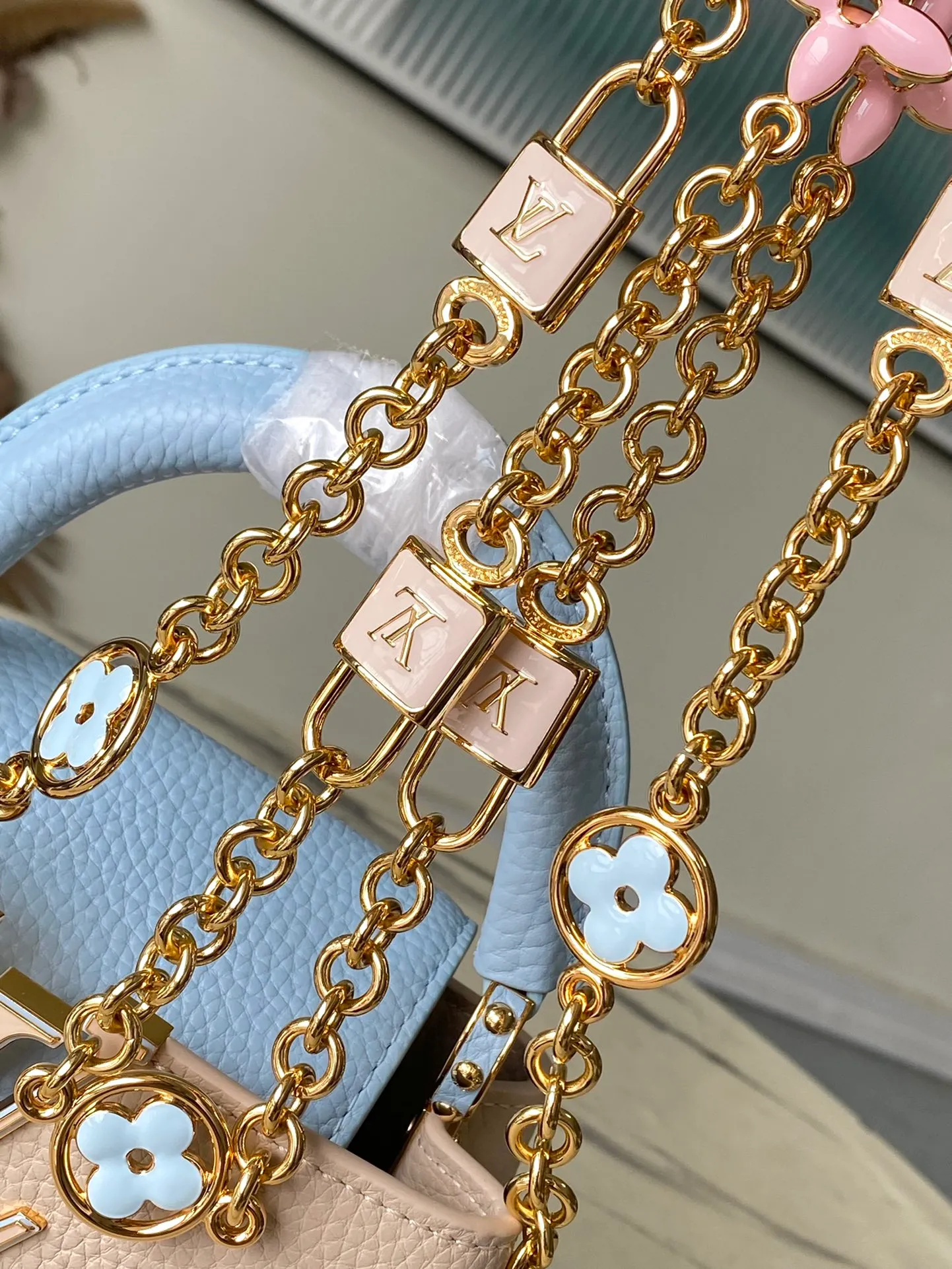 💰2200 (Special grade original leather) M23952 mini This Capucines mini handbag comes from the Lovelock Chain series. The Taurillon leather bag has a dotted rope that looks like a jewelry chain, with a padlock and pastel enamel Monogram flowers, echoing the dual tones of the leather. The detachable chain and top handle provide more carrying options, and the inner pocket is equipped with a small mirror for easy touch-ups at any time. Dimensions: 21 × 14 × 8 cm
