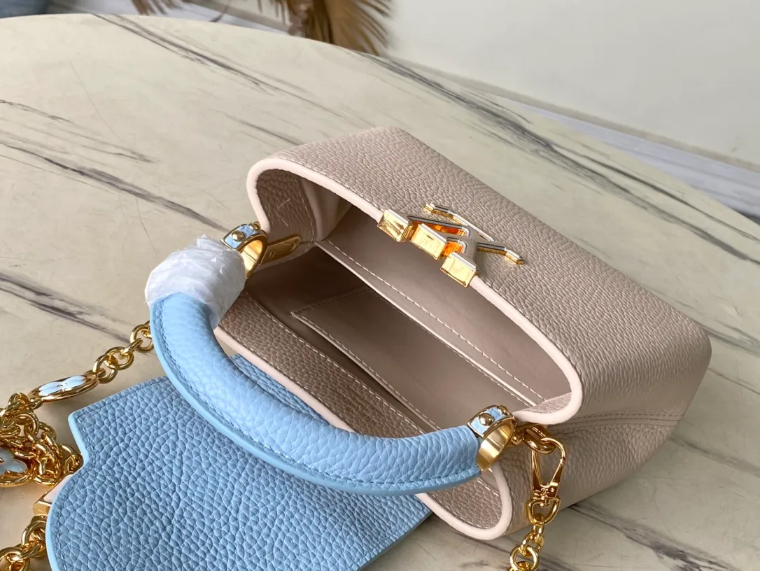 💰2200 (Special grade original leather) M23952 mini This Capucines mini handbag comes from the Lovelock Chain series. The Taurillon leather bag has a dotted rope that looks like a jewelry chain, with a padlock and pastel enamel Monogram flowers, echoing the dual tones of the leather. The detachable chain and top handle provide more carrying options, and the inner pocket is equipped with a small mirror for easy touch-ups at any time. Dimensions: 21 × 14 × 8 cm