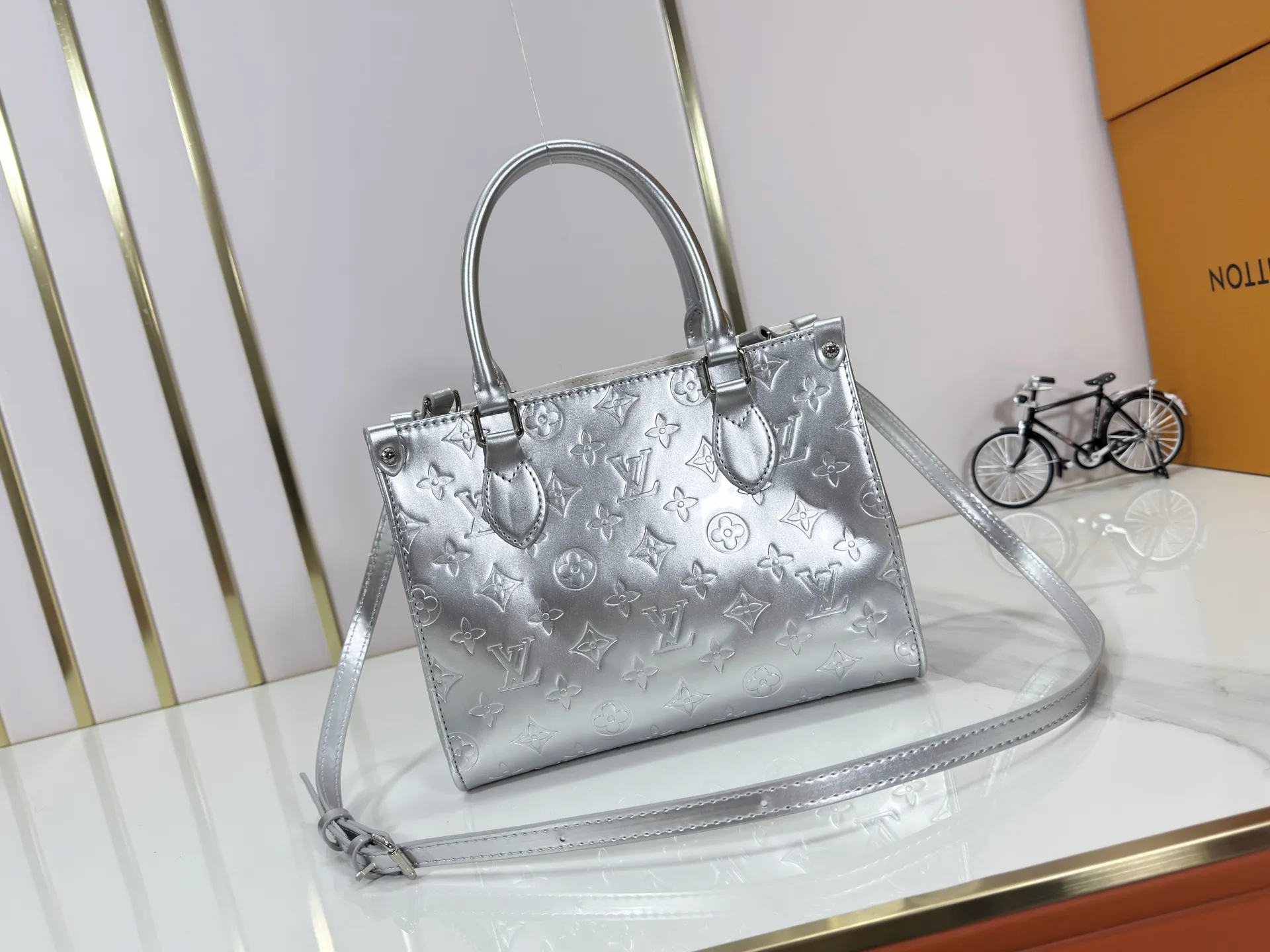 P220 upgraded original M26373 M45659 M44571 This OnTheGo small handbag joins the LV Ski series in the Monogram Miroir version. Laminated canvas ensures durability. Silver hues and tonal hardware create a gleaming look. Built-in pockets can store daily necessities such as small books. Dimensions: 25 x 19 x 11.5 (cm) ((length x height x width)