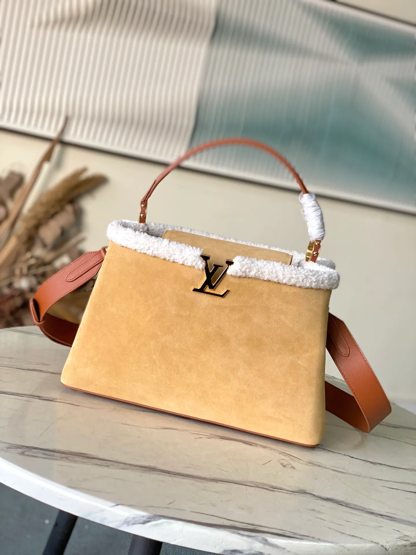 💰2140 (top layer leather) top original order M12784 This large Capucines Souple handbag combines suede cow leather and shearling, with the dazzling LV logo and smooth leather handles to extend the elegance of the LVSki series. The ample size can store daily necessities, A4 documents and travel supplies. Dimensions: 38 × 23 × 16 cm