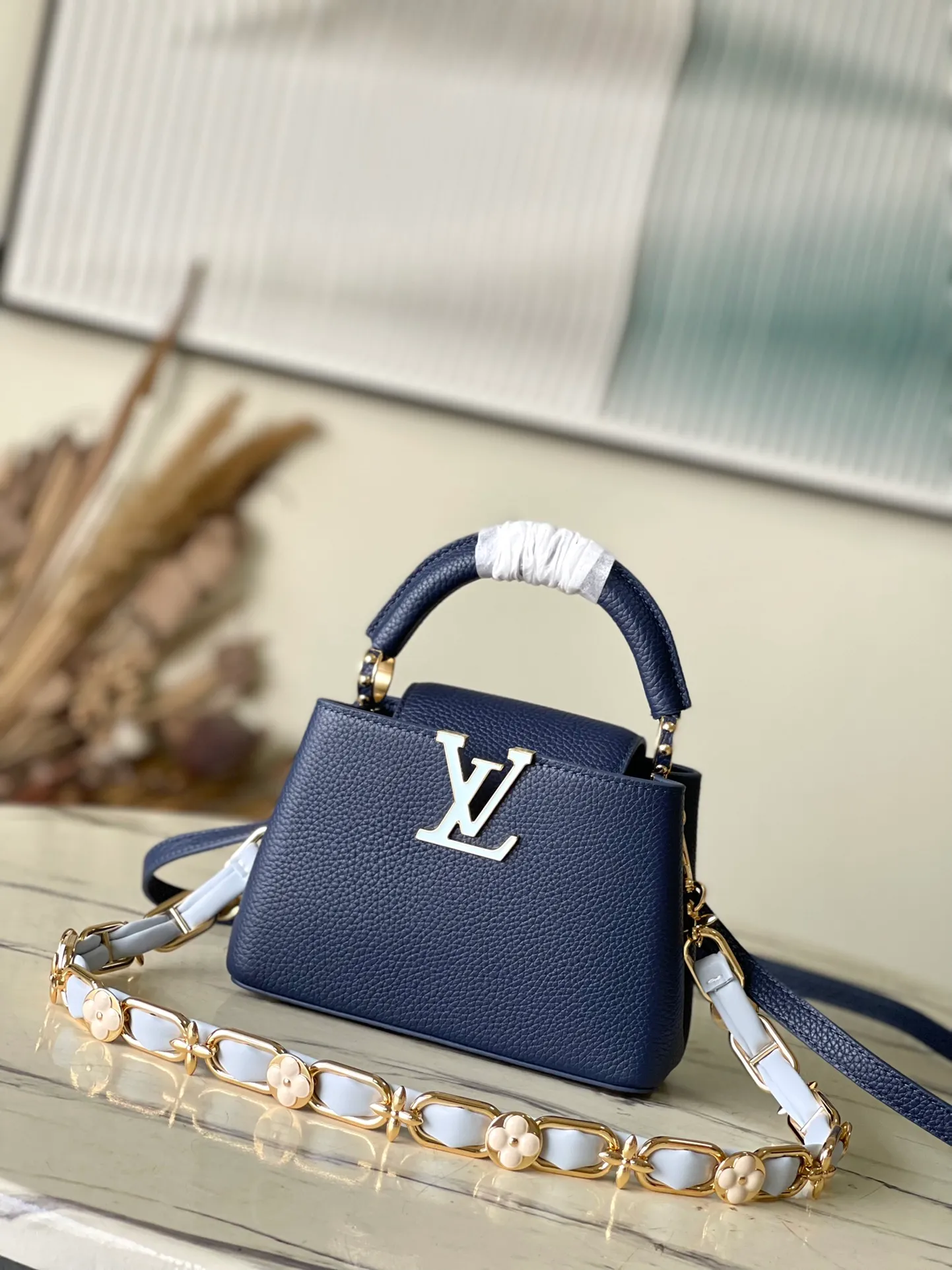 💰2200 (Special grade original leather) M23199 Blue mini This elegant Capucines mini handbag combination is matched with a variety of materials and textures, made of aurilon leather, and equipped with a beautiful new version of Blossom Chain. Metal links and elegant soft cow leather are woven into a delicate chain, inlaid with Swiss enamel and veneer Monogram flowers. The colorful enamel brand logo highlights the texture of jewelry and makes the handbag even more beautiful. Dimensions: 21 × 14 × 8 cm