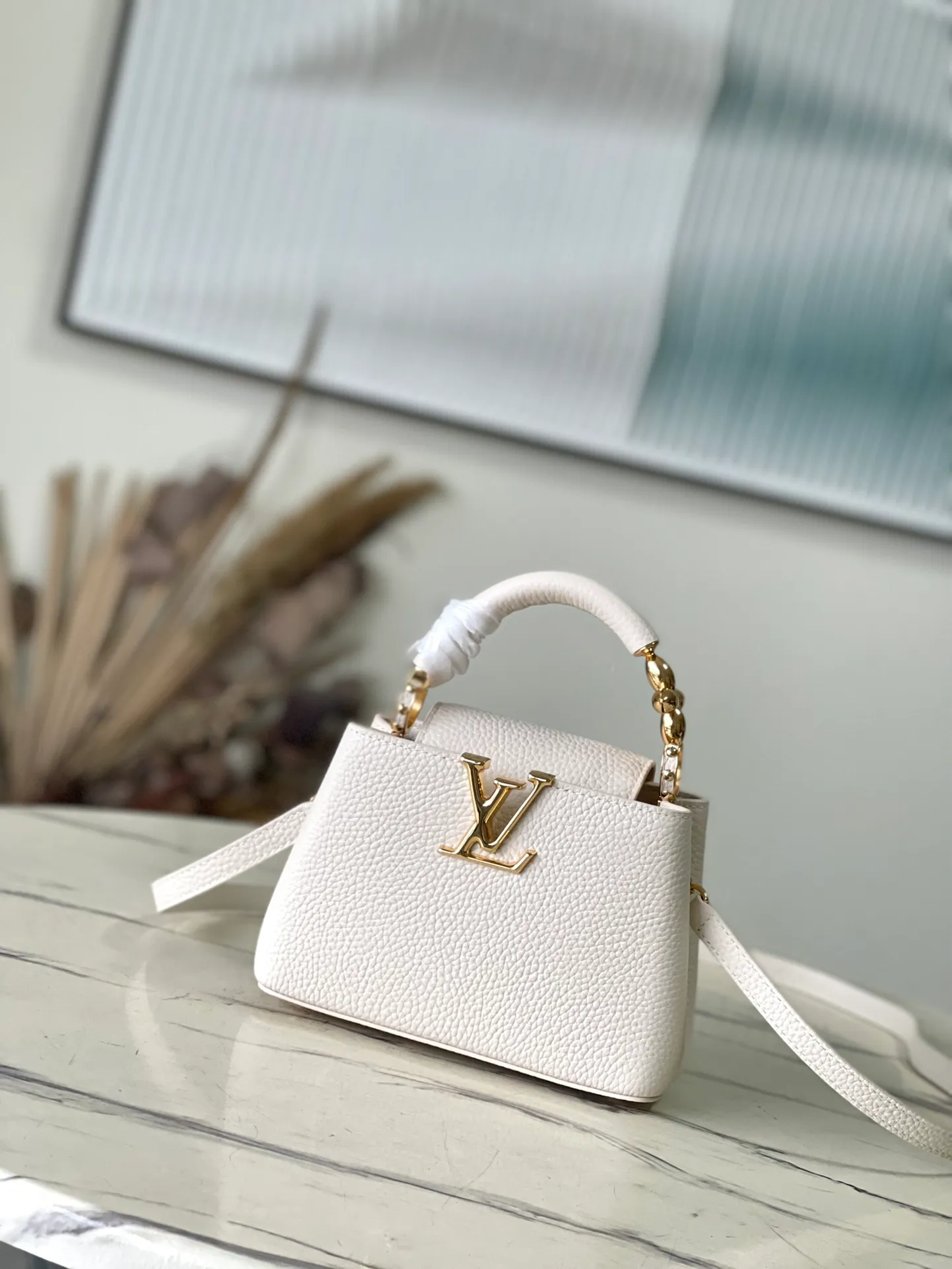 💰2160 (Special Grade Original Leather) M23944 White Mini This Capucines mini handbag incorporates delicate Monogram flowers into the handle, and uses delicate brushstrokes to present the three-dimensional look of the LV logo, injecting dazzling light into the soft design. Full-grain Taurillon leather has a compact shape that can hold a smartphone, short wallet and other small essentials. Dimensions: 21 × 14 × 8 cm