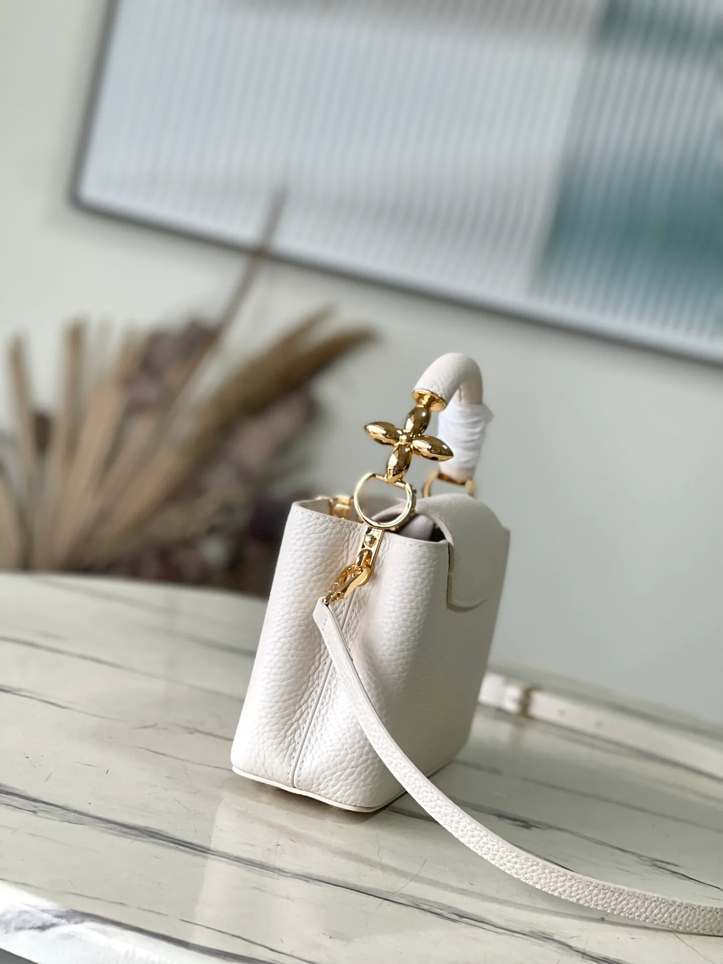💰2160 (Special Grade Original Leather) M23944 White Mini This Capucines mini handbag incorporates delicate Monogram flowers into the handle, and uses delicate brushstrokes to present the three-dimensional look of the LV logo, injecting dazzling light into the soft design. Full-grain Taurillon leather has a compact shape that can hold a smartphone, short wallet and other small essentials. Dimensions: 21 × 14 × 8 cm