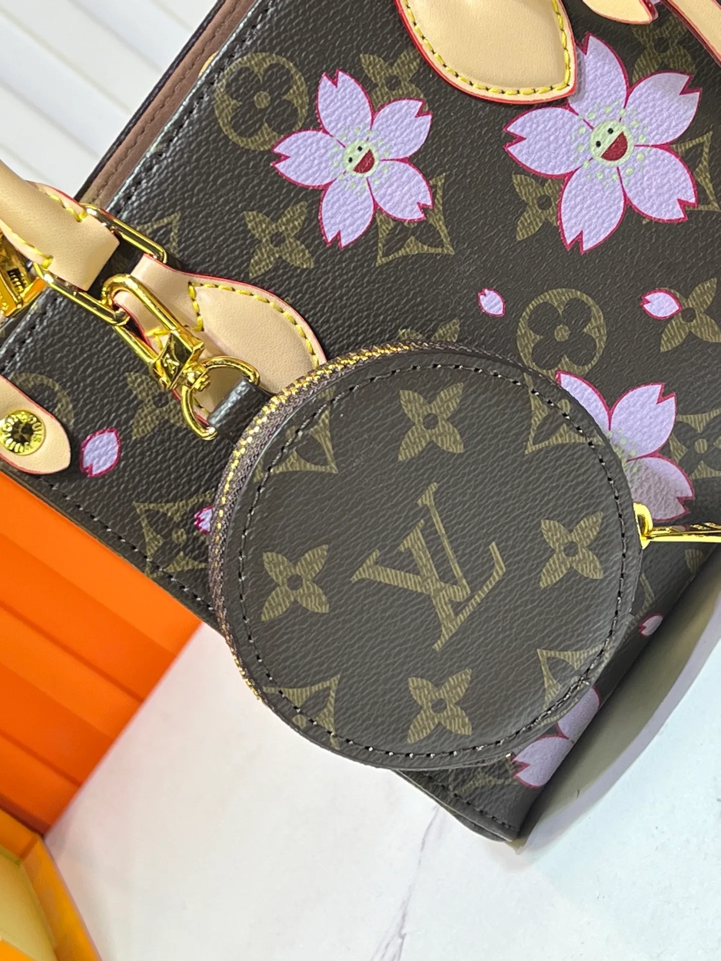 Batch 300💰M45659 M46373🔥Lv&Takashi Murakami🐼Sakura🌸OnTheGo small new version The legendary ONTHEGO handbag: always able to meet your various needs for handbags. It has a large capacity but is not bulky. It is stiff and soft to the touch, making it suitable for home and travel. Tighten the side ties and it instantly transforms into a stylish urban handbag. Loosen the straps and it transforms into a chic and practical handbag. The slender leather handle can be carried over the shoulder or between the arms. The model shown here is made of Damier Azur canvas. Size: 18x15x8.5cm