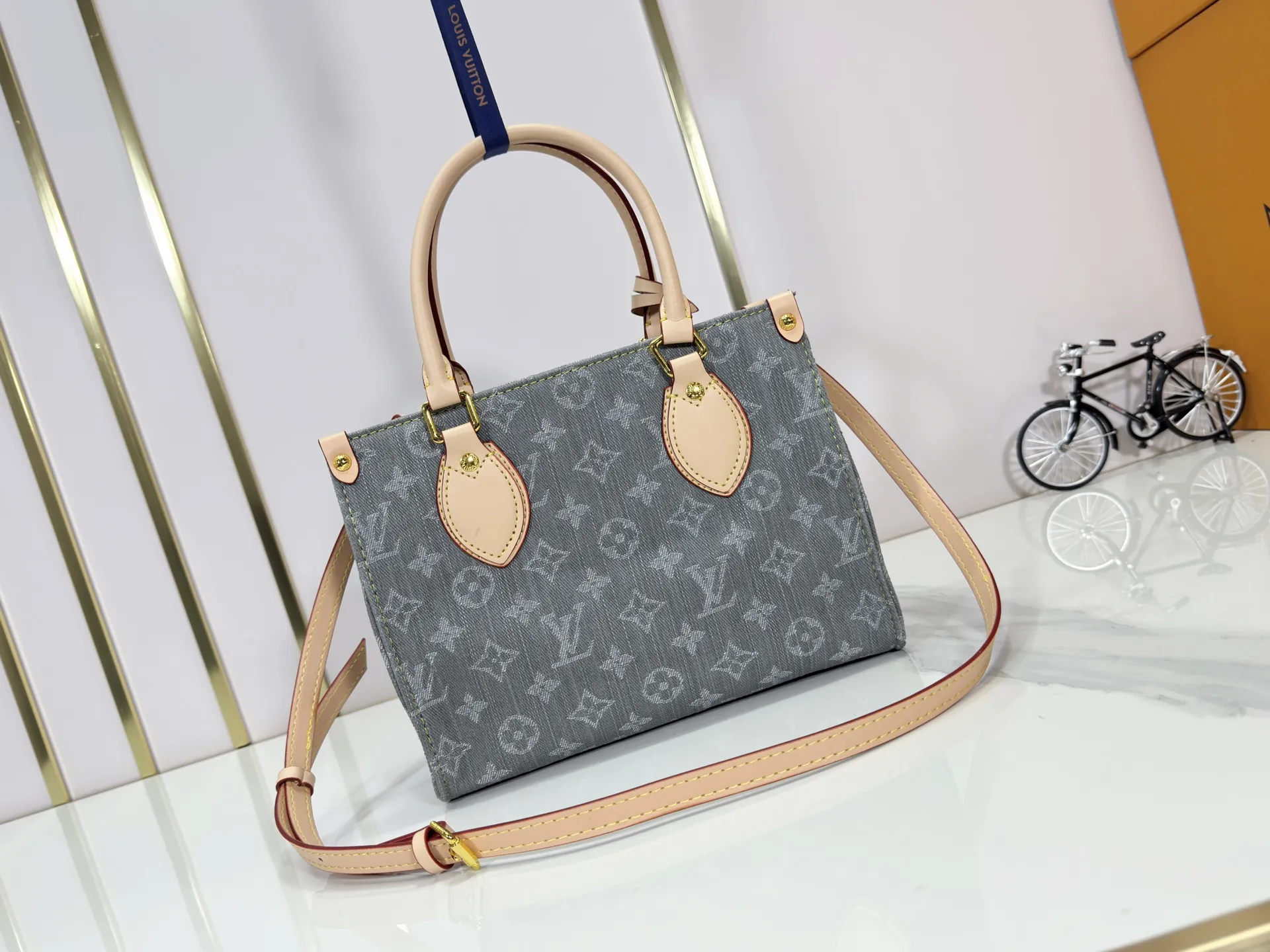 P260 Upgraded original M14633 M46373 Blue denim denim square bag This small OnTheGo handbag is made of cotton denim woven with Monogram pattern. It is bleached and sand washed to present a retro style. Detachable and Adjustable Shoulder Strap for a Subtle Fit The detachable shoulder strap makes it easy to carry small items like an iPad Mini with you. Detailed features 25x 19 x 11.5 cm.