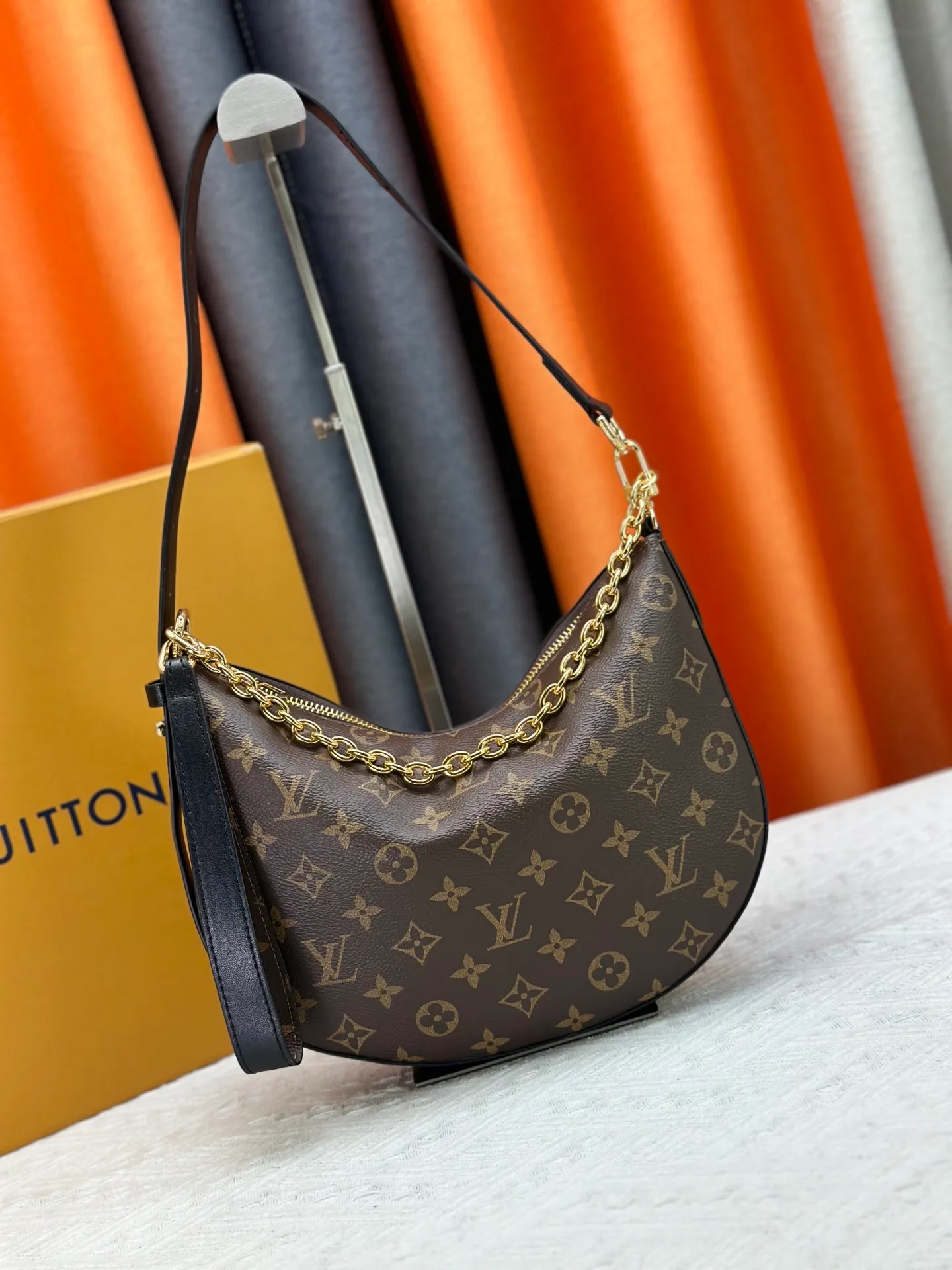P240 Upgraded original M15056 This Cookie BB handbag is made of Monogram coated canvas, with contrasting leather trim to highlight the half-moon shape. The lightweight design combines an adjustable handle and a detachable chain to allow for easy conversion between cross-body and shoulder wear. The two ends of the bag can be connected to create a trendy wrist bag look. Dimensions: 28.5 x 19.0 x 5.0 cm (length x height x width)
