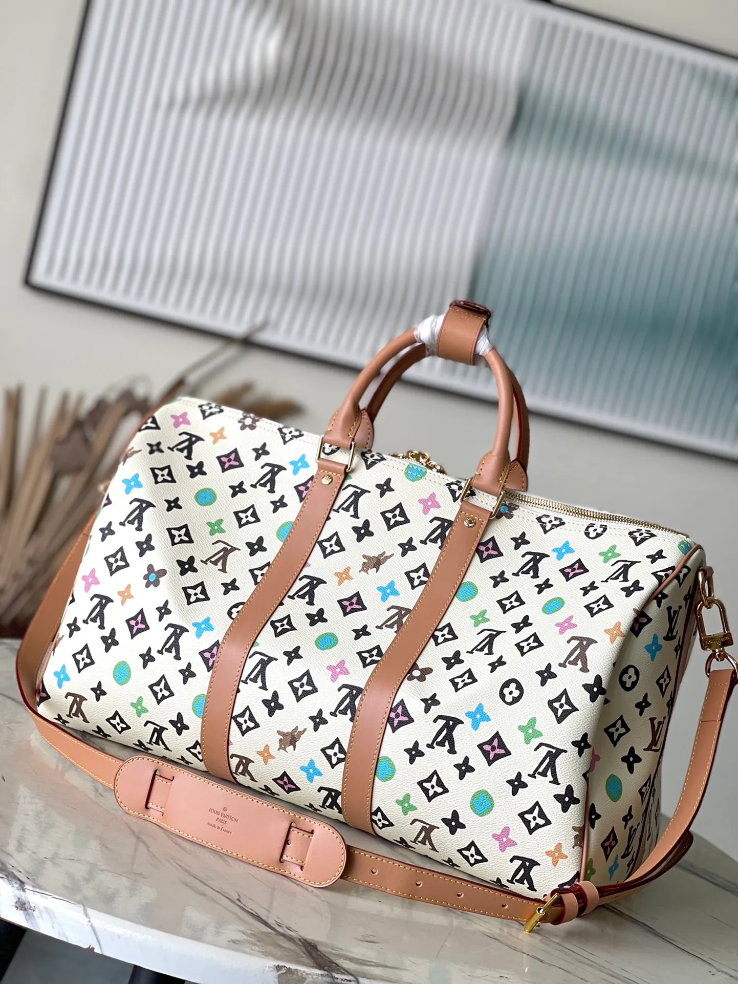 💰1180 Top Original M25233 KEEPALL BANDOULIERE This Keepall Bandouliere45 travel bag is made of colorful Monogram Craggy canvas, showing Tyler's hand-painted Monogram pattern, daisies and hard dog elements. Fine cow leather wraps the top handles, side straps, detachable shoulder strap and detachable wave-effect nameplate. Dimensions: 45 × 27 × 20 cm
