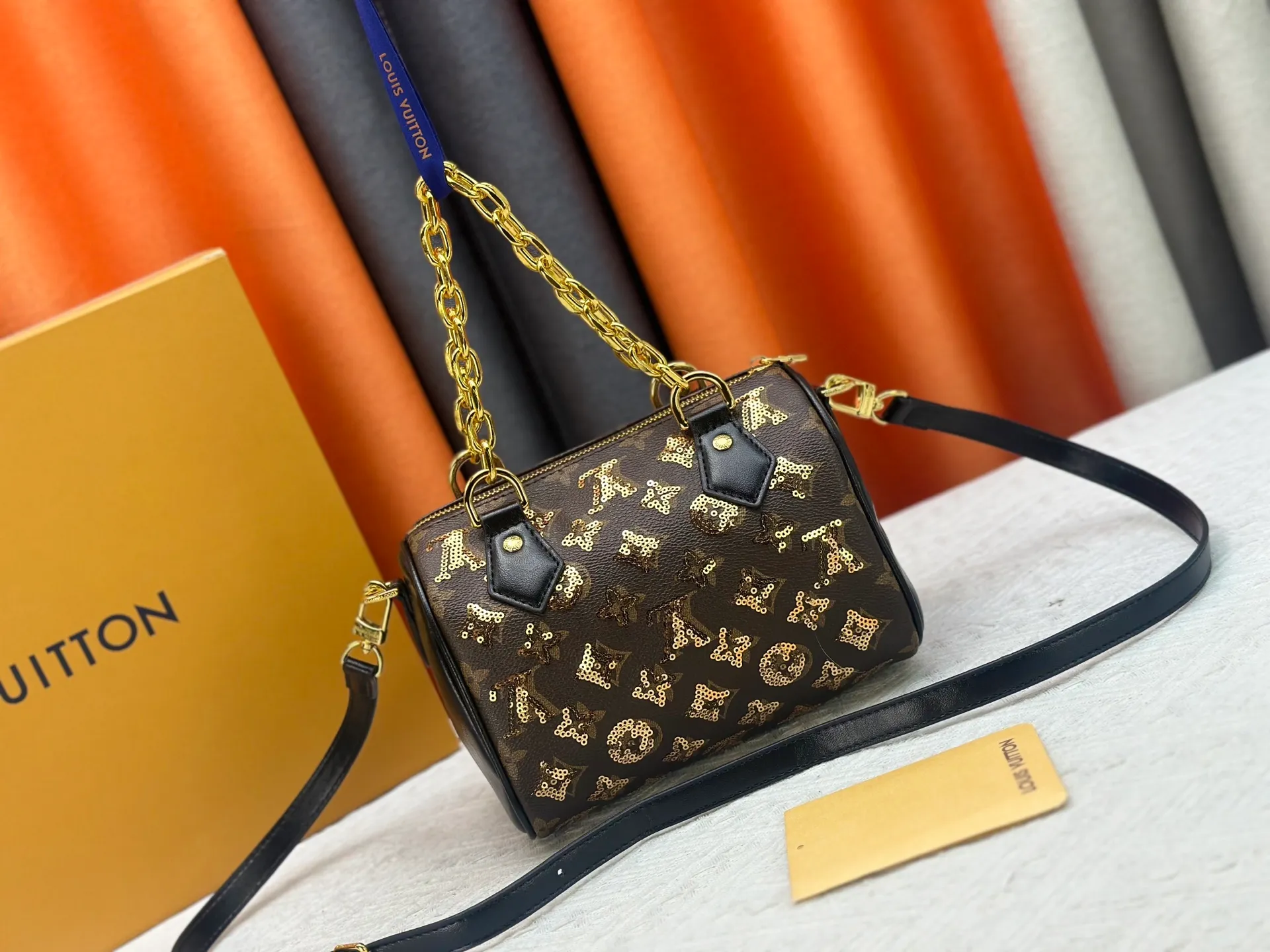 P360 upgraded original M58953 gold sequins M46234 M14291 Speedy Bandoulière 20 handbag is made of soft coated canvas, and the full-length Monogram pattern is traced in colorful rainbow tones, highlighting the smart style of the Louis Vuitton x Murakami reissue series. The Toron handle and detachable shoulder strap are constructed of cow leather, the metal corners recall classic luggage elements, and the bow-shaped key bag and padlock add brand touches. Dimensions: 20.5 x 13.5 x 12.0 cm (length x height x width)