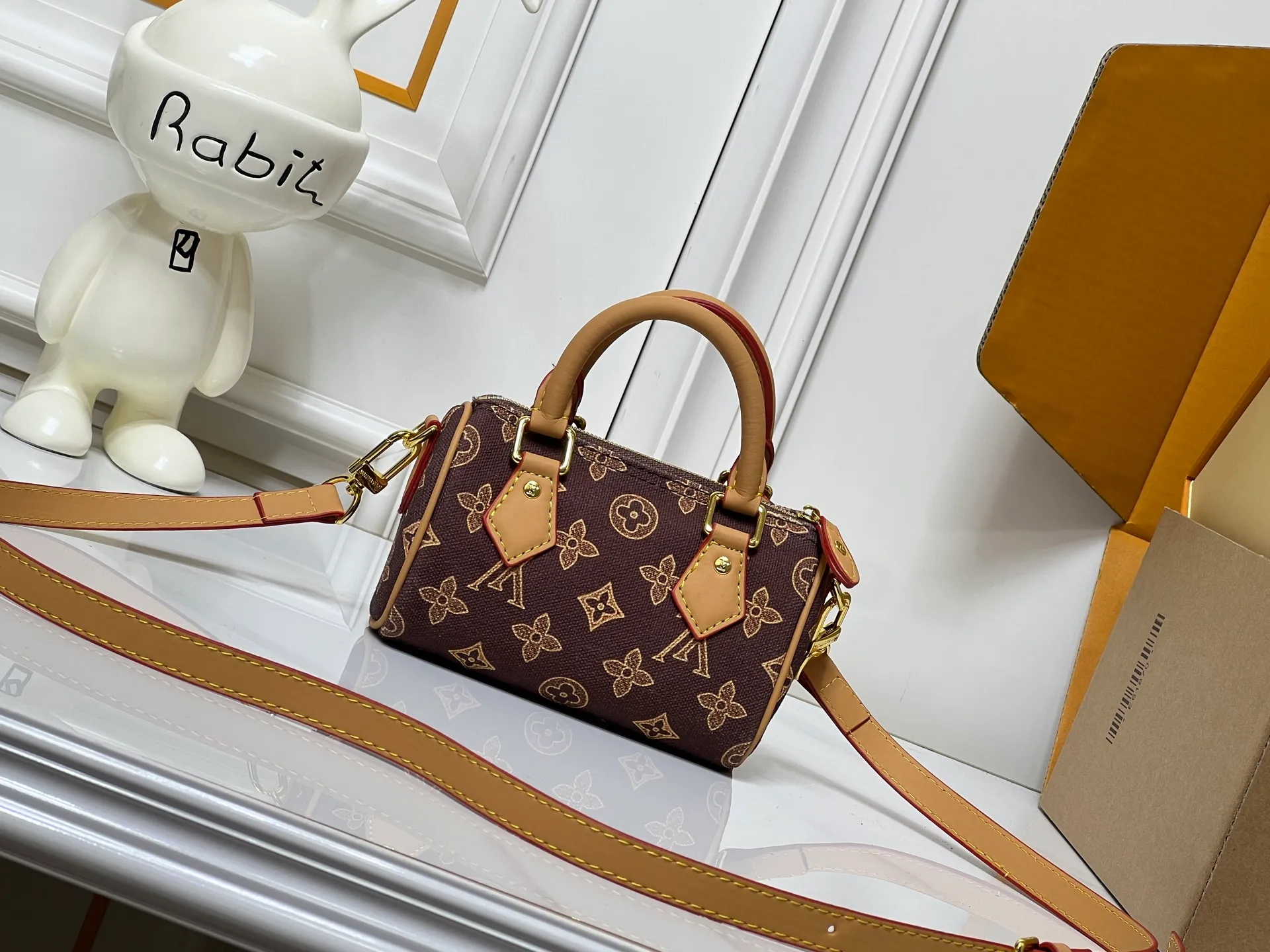 Batch 240💰M28322 Red M28323 M27610 M81085 [Exclusive background shot] This Nano Speedy handbag condenses the configuration of Louis Vuitton's classic Speedy handbag. It is made of Monogram canvas with distressed cow leather details and dazzling metal parts, making it easy to carry with you for daily needs. The handles and removable and adjustable shoulder strap allow for a variety of styling possibilities. 16.0 x 10.0 x 7.5 cm (L x H x W) • Monogram coated canvas • Cow leather trim • Metal hardware • Zipper closure • Space to store daily necessities such as a 6.1-inch smartphone, card holder and lipstick • Shoulder strap: removable, adjustable • Half-length strap: 45.5 cm • Half-length strap adjustable to: 54.0 cm • Handle: Double handle