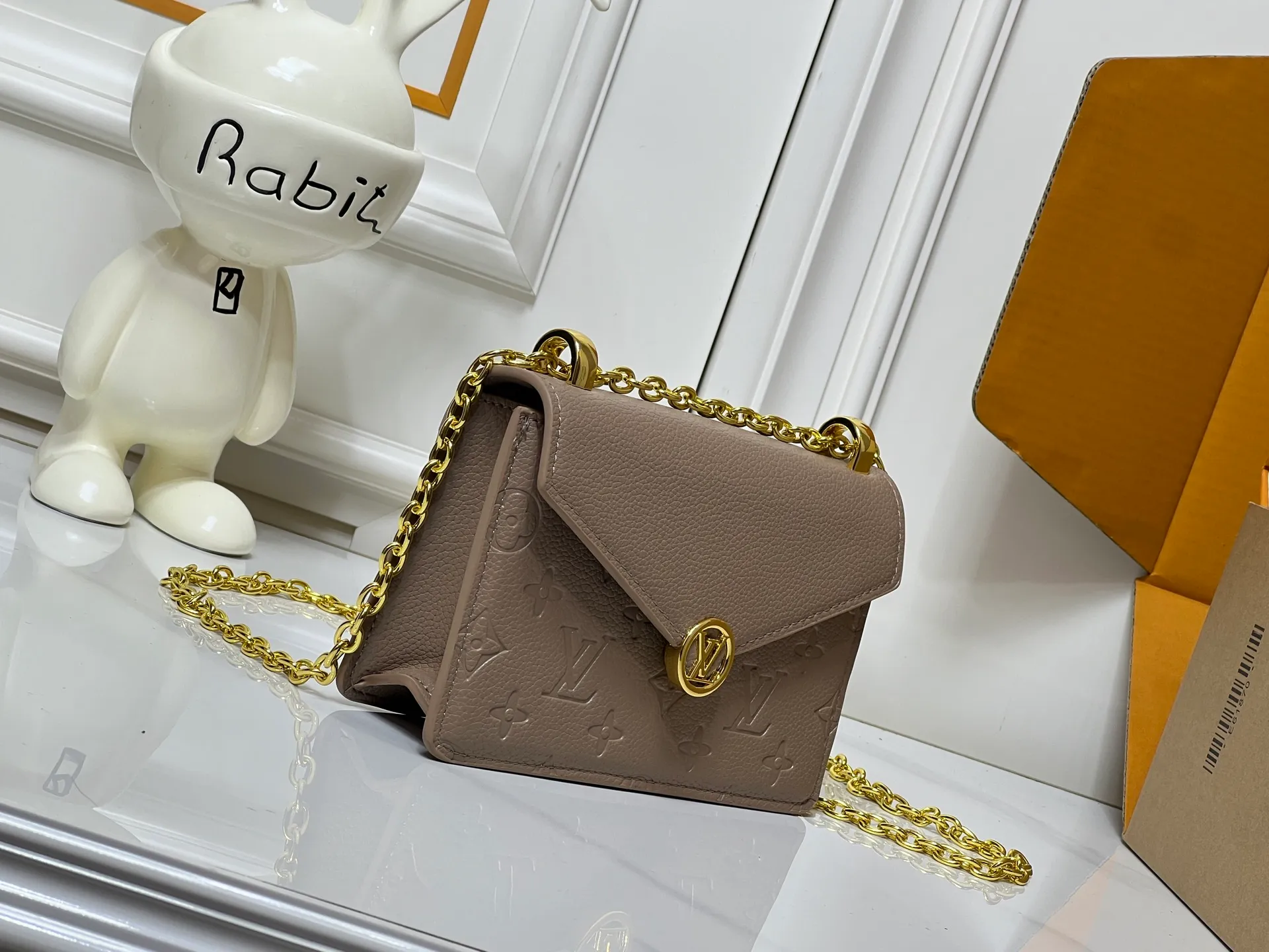 Batch 220💰M13569 black M13570 gray M25814 burgundy (chain/embossed) [Portefeuille chaîne Rosy] This Rosy chain wallet is both fashionable and practical, adding a modern spirit to the Monogram Empreinte series. It has an elegant LV circle and a V-shaped flap, two hallmarks of the house. The magnetic closure reveals a surprise Monogram flower, as well as three card slots and a flat interior pocket. The sliding chain allows you to wear it crosswise or over the shoulder.  Dimensions: 19.5 x 13.5 x 6.5 cm