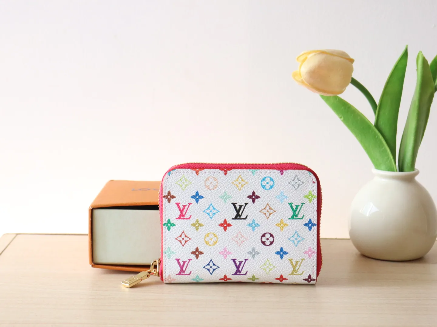 13409 Tricolor Short Zipper Style 🌟P88 LV x TM Zippy Coin Purse M13409 White Color (Tricolor - Murakami) As part of the Louis Vuitton x Murakami series reissue, the timeless Zippy coin purse is practical and playful, upgraded for this season. It's made from Monogram coated canvas in a cheerful rainbow of hues, in keeping with the Japanese artist's signature pop palette. The interior is secured with a silver zipper and is divided into multiple compartments for coins, banknotes and cards. Dimensions: 11 x 8.5 x 2 cm.