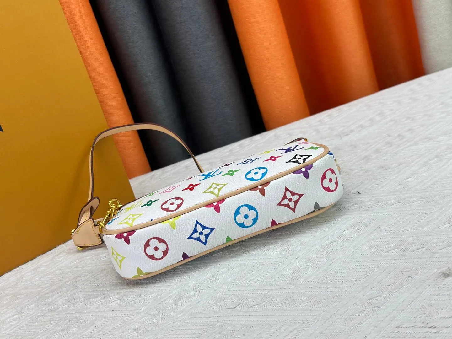 P220 M13404 M13663 Black color White color This Pochette Accessoires handbag is made of coated canvas, with colorful Monogram patterns to interpret the smart style of the Louis Vuitton × Murakami cross-border collaboration series. Calf leather trim and dazzling hardware add to the sophisticated details, while the detachable shoulder strap and chain provide flexible carry. Size: 22x13x4cm