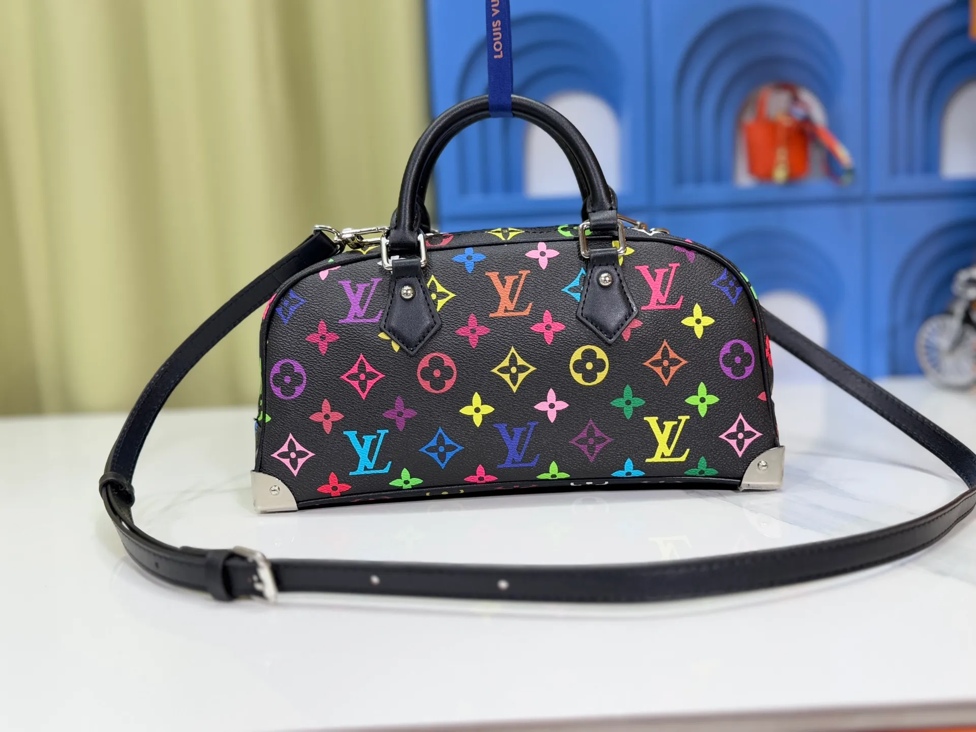 P300 Upgraded Original M13084 This Handbag East West handbag is from the Louis Vuitton x Takashi Murakami reissue series, using the artist's signature rainbow tones to trace the full-length Monogram pattern. Sleek horizontal construction lines the top handle, studded side straps, detachable and adjustable shoulder strap and LV x TM key holder, with cowhide leather details and sophisticated corners that nod to the brand's traditional luggage. Dimensions: 27.0 x 14.0 x 10.0 cm (length x height x width)