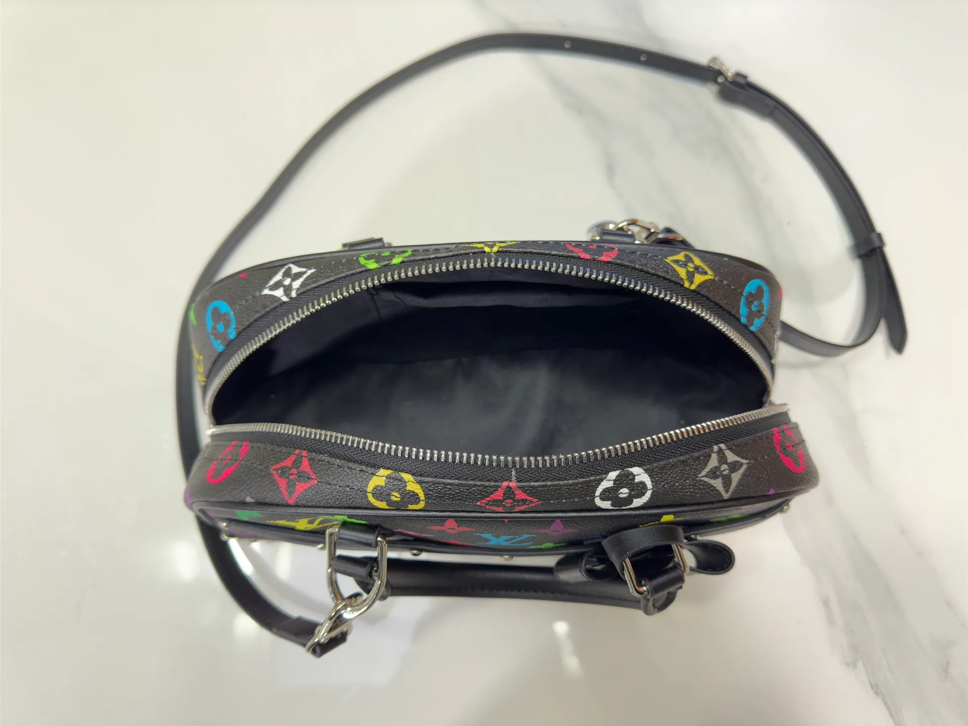 P300 Upgraded Original M13084 This Handbag East West handbag is from the Louis Vuitton x Takashi Murakami reissue series, using the artist's signature rainbow tones to trace the full-length Monogram pattern. Sleek horizontal construction lines the top handle, studded side straps, detachable and adjustable shoulder strap and LV x TM key holder, with cowhide leather details and sophisticated corners that nod to the brand's traditional luggage. Dimensions: 27.0 x 14.0 x 10.0 cm (length x height x width)